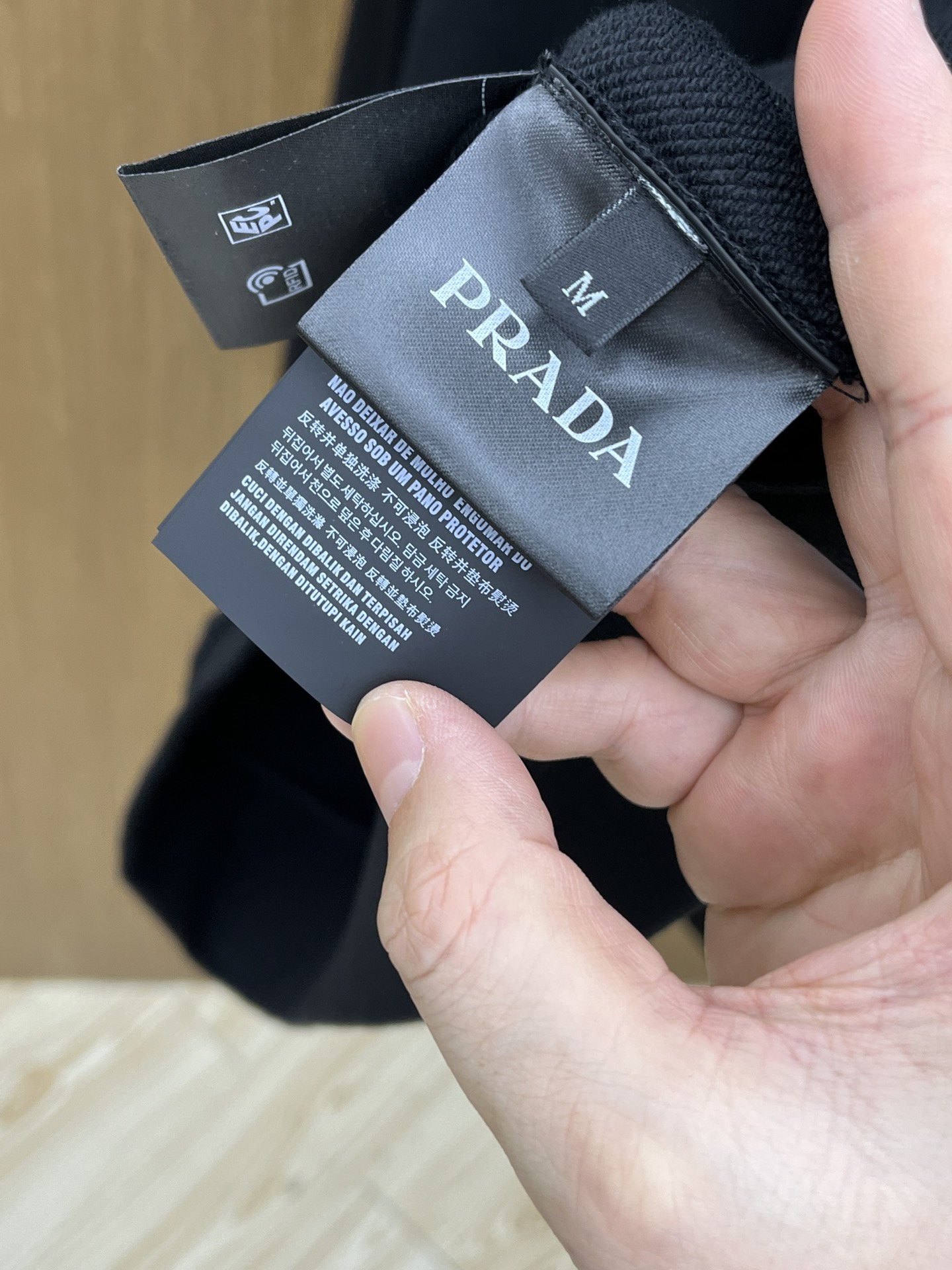 普拉达Prada这款黑色连帽卫衣，简直是时尚与舒适的完美融合体。经典的纯黑主色调，自带高级感滤镜，无论什