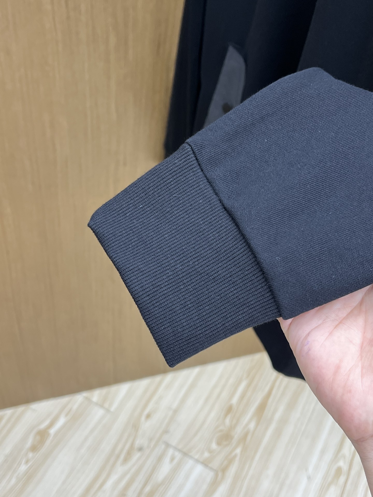 普拉达Prada这款黑色连帽卫衣，简直是时尚与舒适的完美融合体。经典的纯黑主色调，自带高级感滤镜，无论什