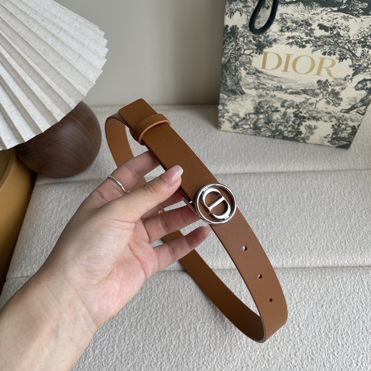  Dior这款腰带采用光滑牛皮革等材质精心制作，搭配富有光泽的金色饰面金属环圈CD腰带扣提升格调。可与经