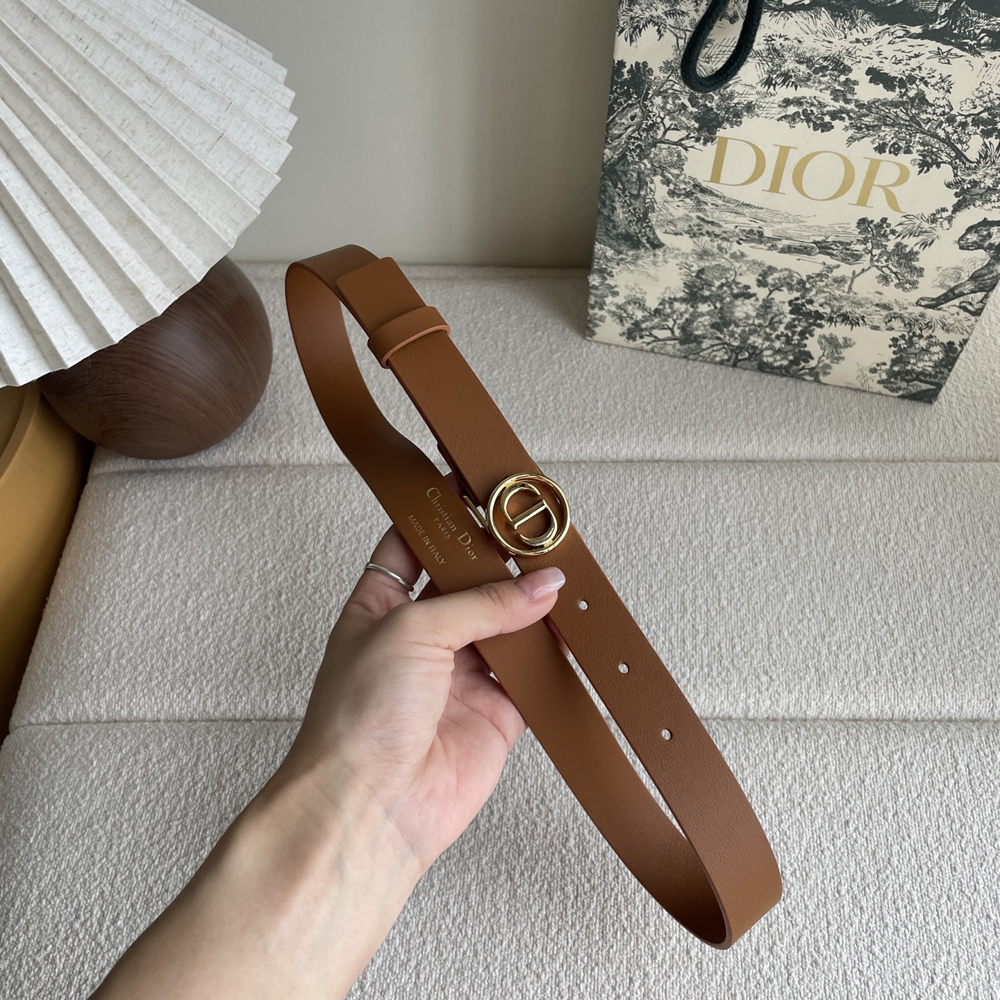  Dior这款腰带采用光滑牛皮革等材质精心制作，搭配富有光泽的金色饰面金属环圈CD腰带扣提升格调。可与经