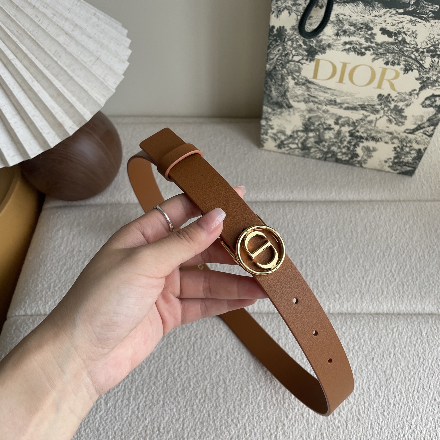  Dior这款腰带采用光滑牛皮革等材质精心制作，搭配富有光泽的金色饰面金属环圈CD腰带扣提升格调。可与经