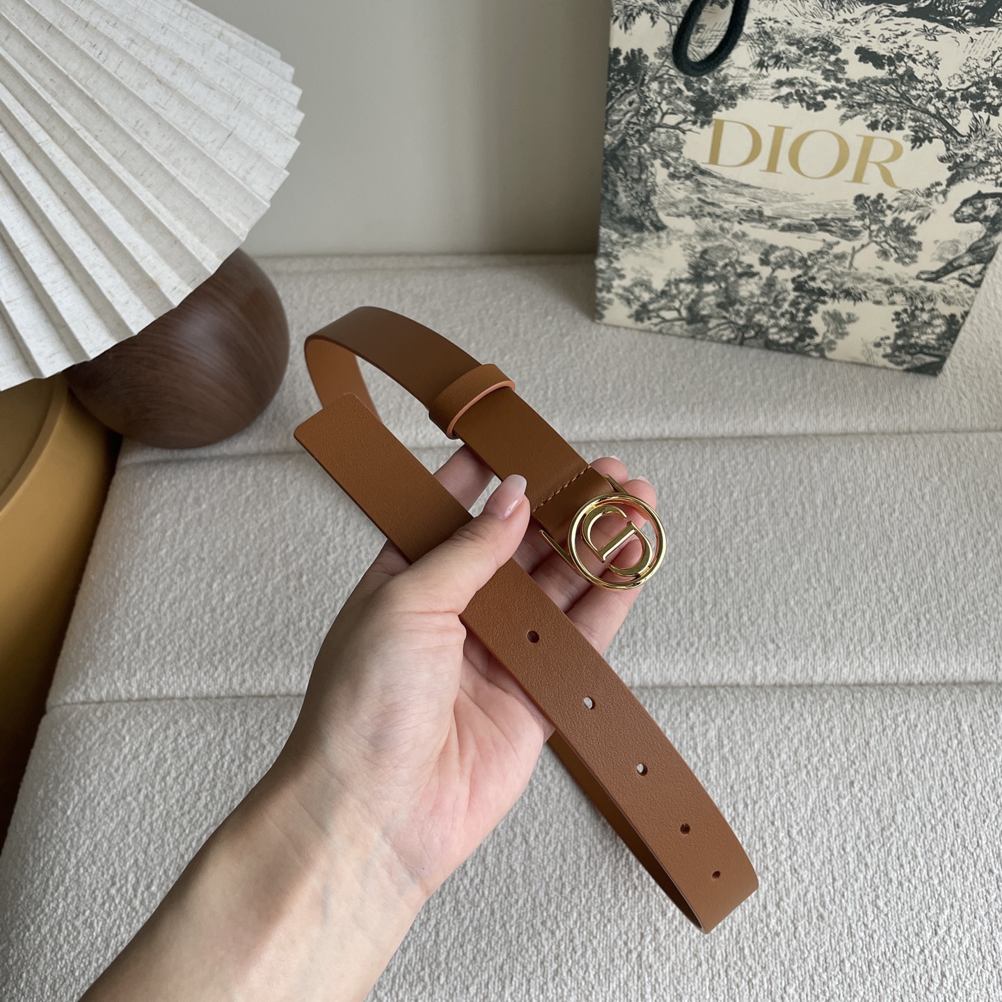  Dior这款腰带采用光滑牛皮革等材质精心制作，搭配富有光泽的金色饰面金属环圈CD腰带扣提升格调。可与经