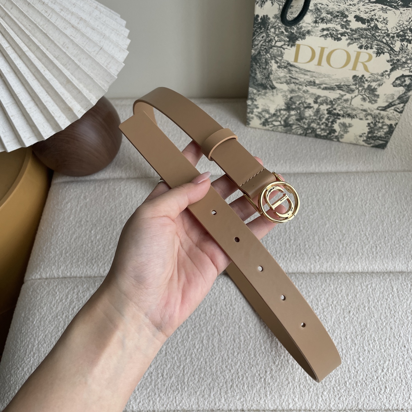  Dior这款腰带采用光滑牛皮革等材质精心制作，搭配富有光泽的金色饰面金属环圈CD腰带扣提升格调。可与经