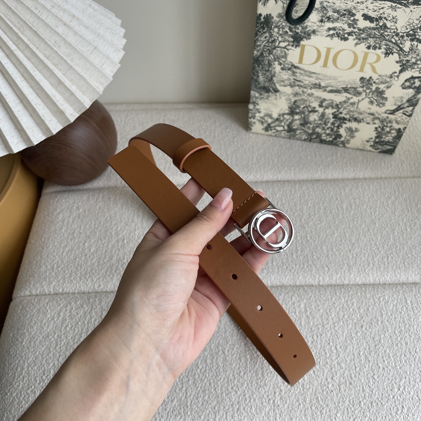  Dior这款腰带采用光滑牛皮革等材质精心制作，搭配富有光泽的金色饰面金属环圈CD腰带扣提升格调。可与经