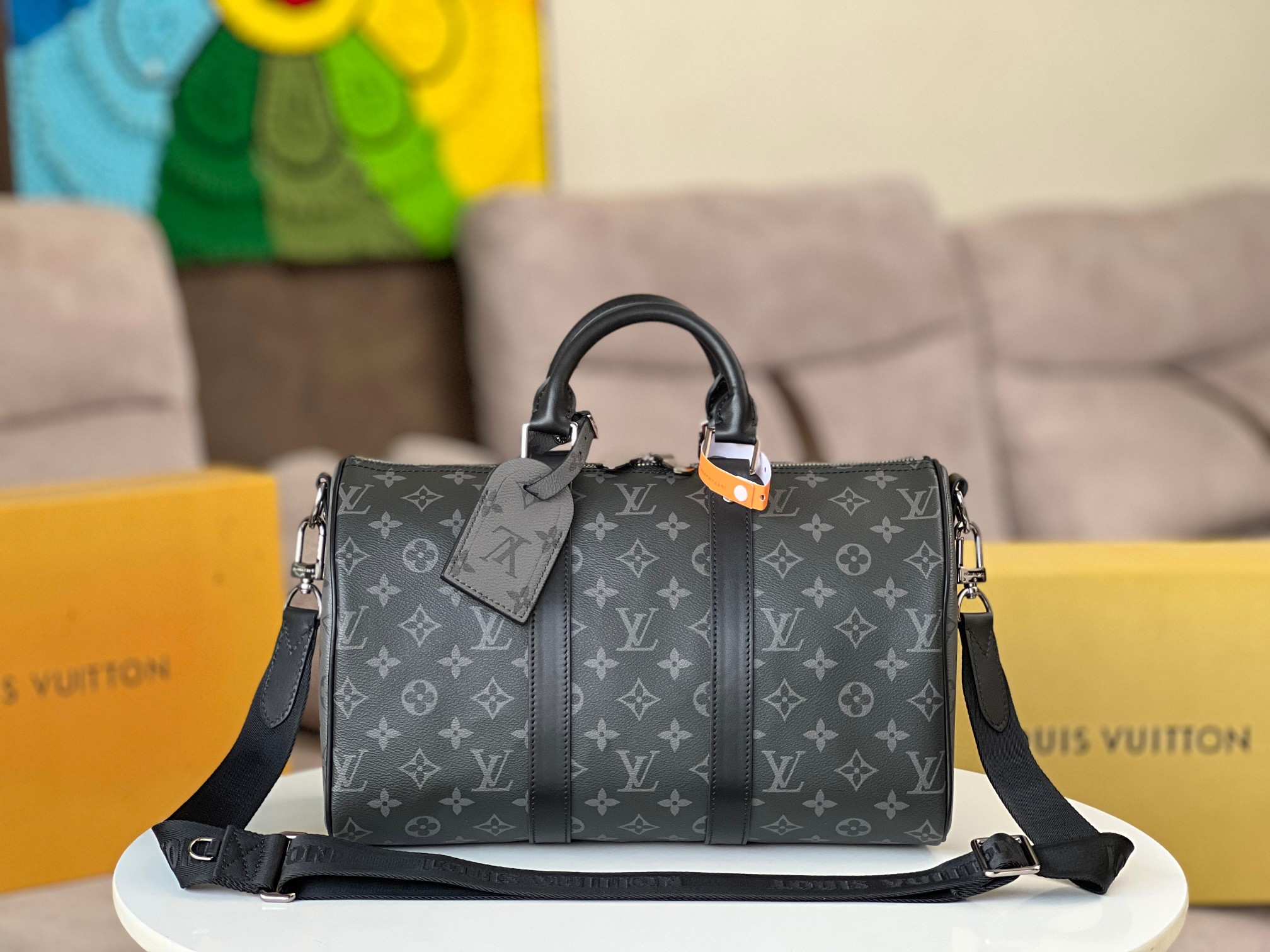 pLW顶级原单【 M黑花 】Keepall 旅行袋，由全新标志性 Monogram Eclipse 帆布裁制而成。自 JE 年以来，Keepall 系列包袋陪伴着一代又一代的旅行者云游四海。此款新版旅行袋配有多个提握舒适的皮革手柄、一条适用于闲适斜挎的包带以及一个闪亮的挂锁，短途旅行的伴侣。 侧带和顶部轧制皮革手柄承袭经典 Keepall 旅行袋设计，可拆卸并调节的织物肩带方便肩背或斜挎，容量相比 City Keepall 手袋略有增加 size：xxcm