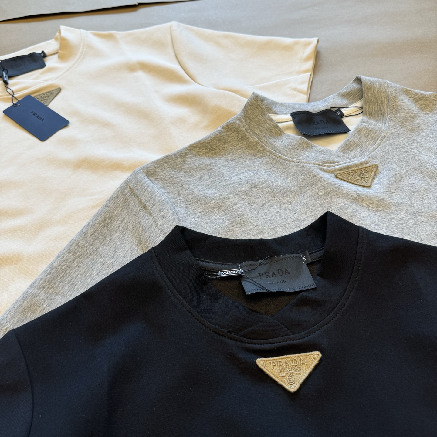 💰115
Prada 2025Fw 普拉达液氨棉花瓣领正肩短袖T恤
小领口花瓣领的设计重磅硬挺有型 普拉达把Cleanfit极简风玩到这么高级的只有它了 无论上身还是摸上去更加高级 小领口设计完美修饰脖子线条 区别市面上宽松落肩袖 这款boxy正肩版型能更完美的展示身材比例 这种高级感才是经得起琢磨的美 胸前定制Prada亚麻绣倒三角贴标 简约而不简单 大厂做工 三标辅料齐全 男女情侣款

Color：花灰/黑/米灰
Size：m～xl