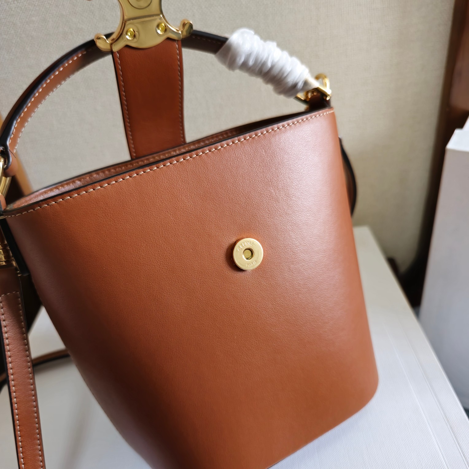 p680。 新品上线🅰️🅰️ CE家新款mini桶包 
e 采用光泽细腻的小牛皮塑造洗练流畅的水桶廓型，深邃背景烘托精巧闪亮的金色Triomhe凯旋徽标 ，呈现轻松随性气质 ，手袋配置手提和可拆卸肩带，容量非常可观 日常通勤 出差 办公完全无压力🤎 
款号：101473
颜色：棕色
尺寸：13.5x16x10cm
（配原版包装）