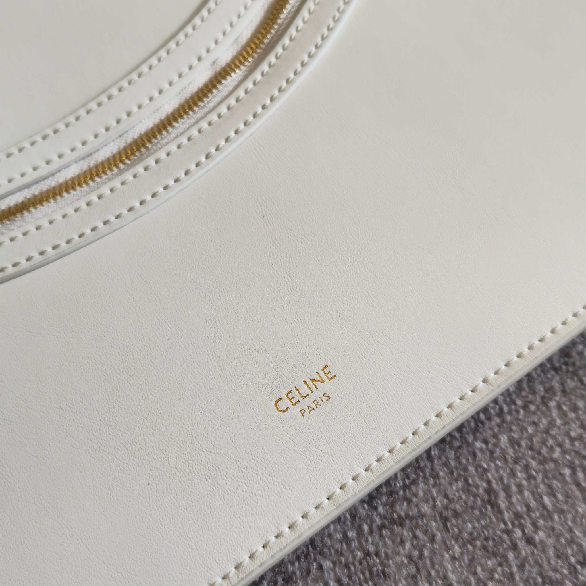 p750。 新品上线🅰️🅰️ 2026年春夏新款笑脸包. 
十几年前的 It Bag，Ce 笑脸包回归啦&hellip;&hellip;
Ce26春夏大秀，Michael Rider 将10年诞生、红极一时的&ldquo;笑脸包&rdquo;带回大众视野。
除了廓形变得更加窄长、囧脸变笑脸以外，还推出了超薄造型的 Flat Cabas 笑脸包。秀款中还有许多不同Size、配色亟待推出✅
款号：123963
颜色：白色
尺寸：44.5x31.5x0.5cm