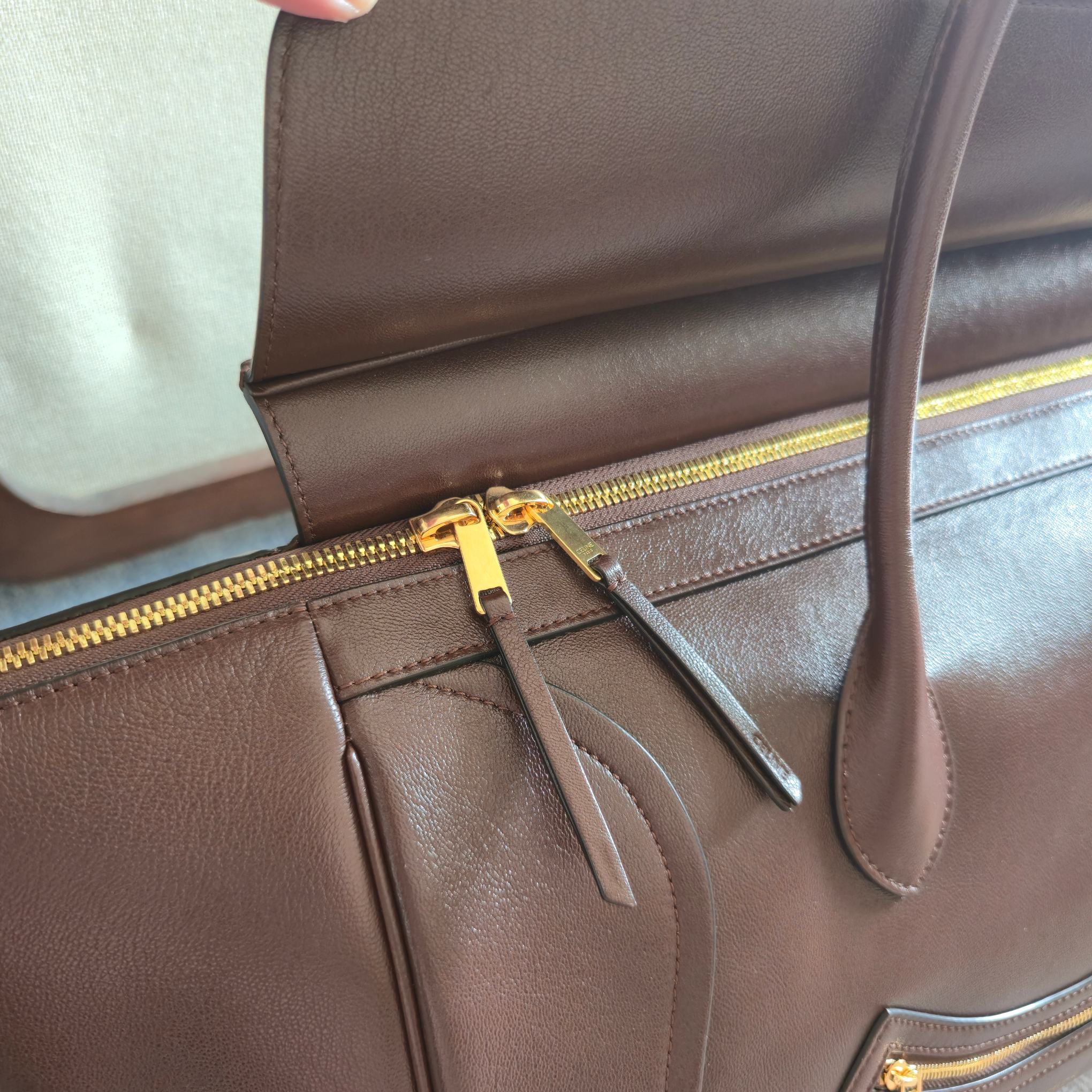 p1080。 大号44cm 新品上线 26春季系列全新笑脸包👛
😐变🙂，CE笑脸包焕新回归！
CE PRINTEMPS 2026春季系列！
NEW LAGE新版笑脸包
记忆中的经典，焕新登场！
👜轻盈的材质，摩登的线条
依旧是那个辨识度拉满的It Bag！
尽显简约利落的摩登气质。新任创意总监 Michael Rider 在2026春季首秀上让&ldquo;笑脸包&rdquo;惊喜回归，柔滑细腻且富有光泽的皮革，背缝工艺和滚边设计塑造出柔和圆润的横版轮廓，侧面拉链设计呈现独特的微笑弧度，巧妙呼应&ldquo;笑脸包&rdquo;这一美名。通过现代廓形重释经典设计，整体更加轻便百搭，呈现优雅又随性的风格！
款号：123683
颜色：深棕色
尺寸：底部44x16x30cm
袋口69cm