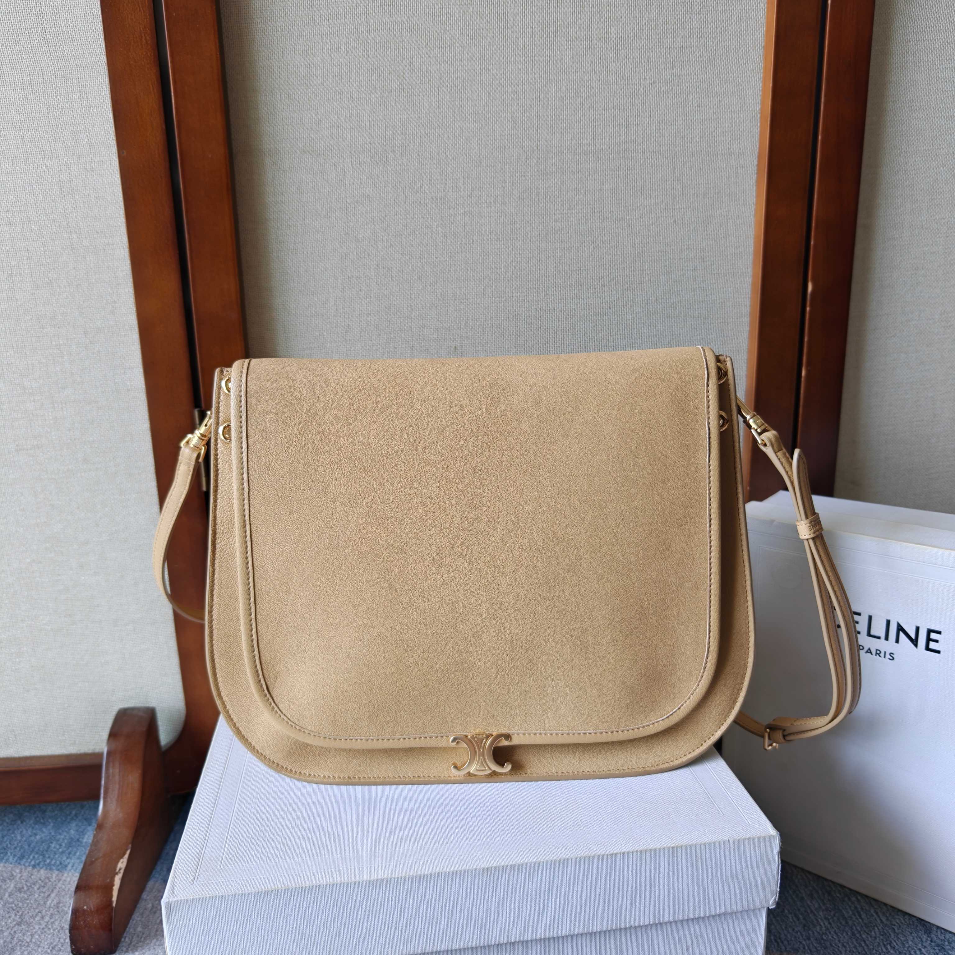 NO:853156,A Besace handbag, the latest Soft Triome Besace. The recently popular Soft Triome Besace is a new style for the spring and summer of 2026, focusing on a 'lazy and fashionable' feeling. Bag design: Compared with the classic half-moon bag, this Besace is more square. The box-shaped structure makes it look more rigid and has a larger capacity. It can easily hold a folding umbrella, a thermos cup and a bag.  Material and feel: Made of soft natural grained shiny lambskin, it has a delicate feel and is very light in weight, so it is not burdensome to carry. Practical details: There is a zipper pocket on the back of the bag, which can be used to store keys or keys, which is very convenient. The magnetic buckle is low-key, with the Triome emblem, and has a crisp 'click' sound when opening and closing. Various carrying methods: equipped with a detachable and adjustable shoulder strap, which can be worn on the shoulder, crossbody, or  It can be carried hand-held, and it looks like a French lady when paired with a suit. Style number: 123632 Size: 32x2x26cm (with original packaging), Celine [price based on quantity], celine, business suit, sheepskin19860909A Besace手袋 最新款 Soft Triome Besace 最近很火的Soft Triome Besace是2026春夏的新款,主打一 个“慵懒时髦”的感觉. 包型设计:相比经典的半月包,这款 Besace 更加方正一些, 箱型结构让它看起来更挺括,容量也更大,能轻松装下折叠伞、 保温杯和包. 材质与手感:采用柔软的天然粒面亮泽小羊皮,手感细腻,自 重很轻,背起来没有负担. .实用细节:包身背面有一个拉链口袋,可以放或钥匙,非常方 便.磁吸扣是低调的, Triome徽记,开合时有清脆的“咔哒”声. 背法多样:配有可拆卸和可调节的肩带,可以单肩、斜挎,也 可以手提,搭配西装很有法式小姐姐的感觉. 款号: 123632 尺寸:32x2x26cm (配原版包装》,赛琳【跑量价】,celine,business suit,sheepskin,Bag