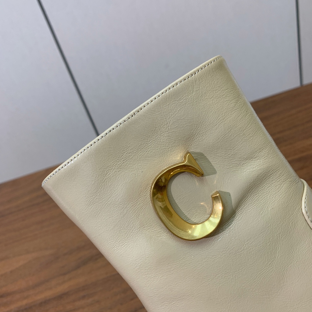 【 D*or 】及踝靴粗跟短靴。两侧搭配CD扣，后侧饰以金色饰面金属 CD 标志，可为本季各式造型增添点