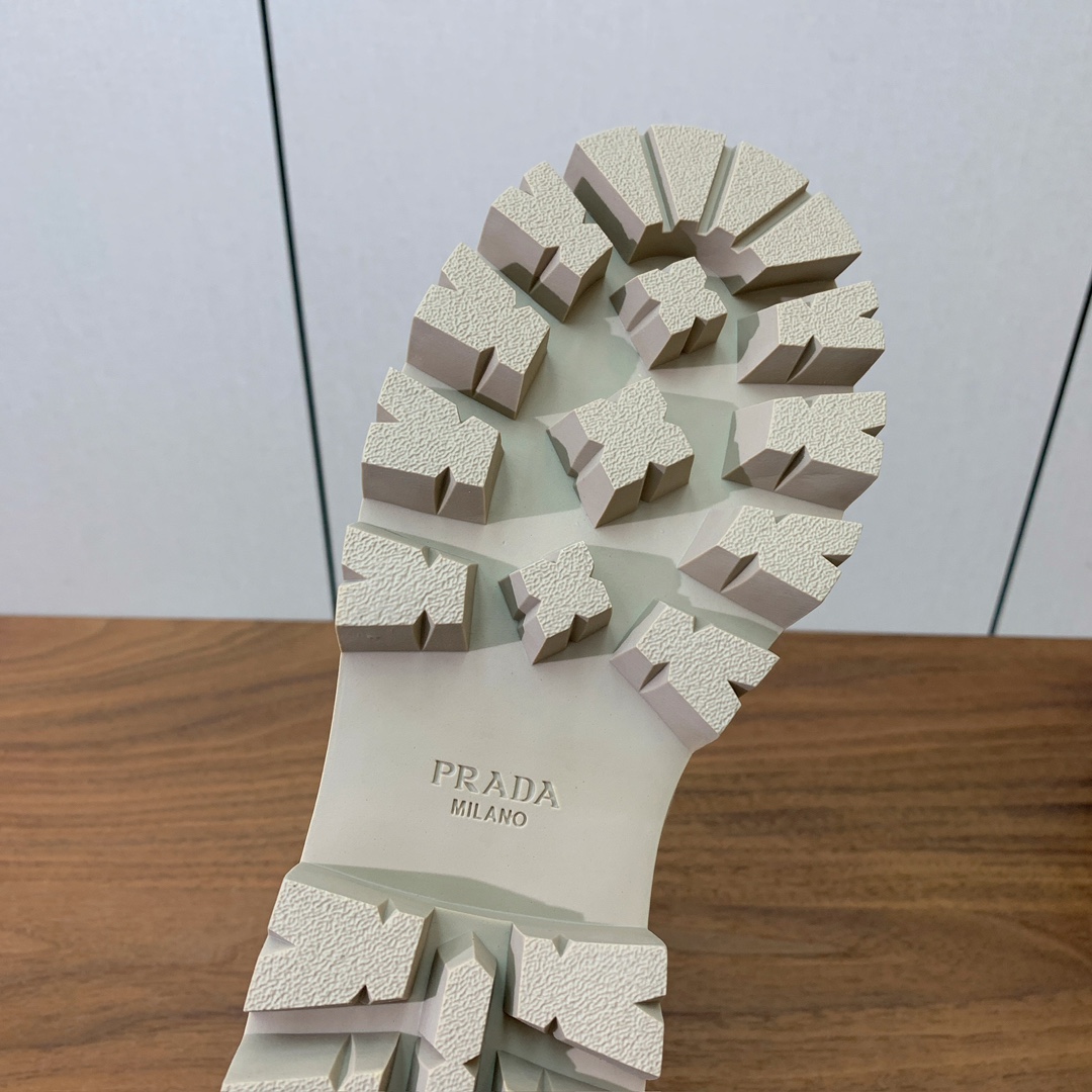 【Prad*】三角金属标短靴。涂珐琅三角形金属徽标装饰彰显品牌格调。惯用于精美鞋履的复古亮面皮革，打造别