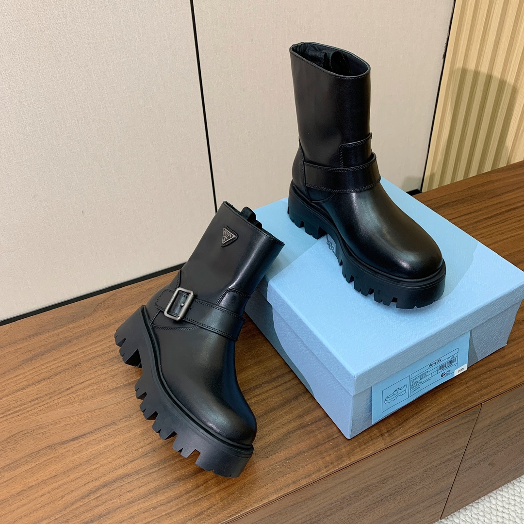 【Prad*】三角金属标短靴。涂珐琅三角形金属徽标装饰彰显品牌格调。惯用于精美鞋履的复古亮面皮革，打造别