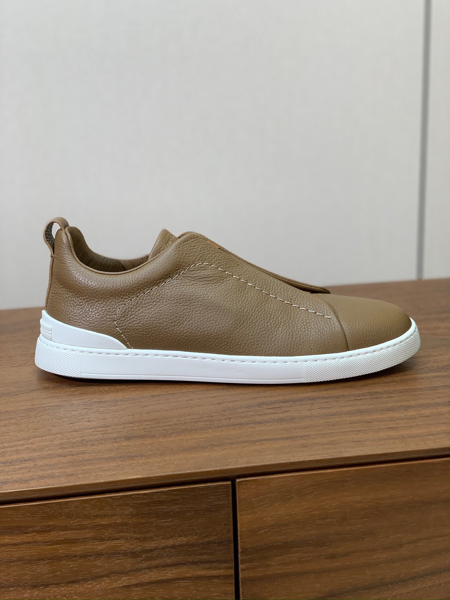 【Zegna】荔枝纹一脚蹬休闲鞋。饰有标志性三重交叉松紧细节，灵感源于三重手缝线迹造型，彰显了杰尼亚的悠