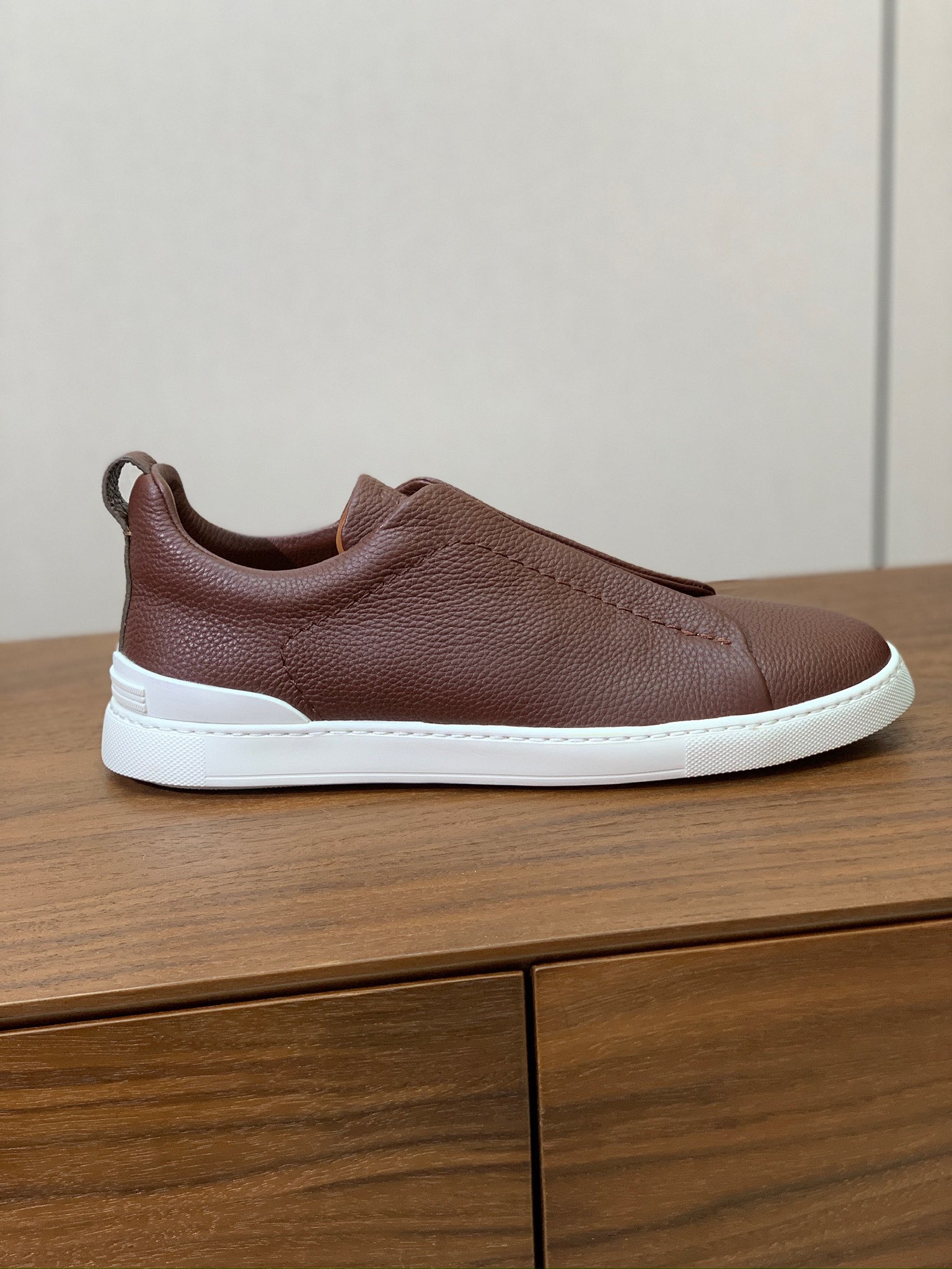 【Zegna】荔枝纹一脚蹬休闲鞋。饰有标志性三重交叉松紧细节，灵感源于三重手缝线迹造型，彰显了杰尼亚的悠