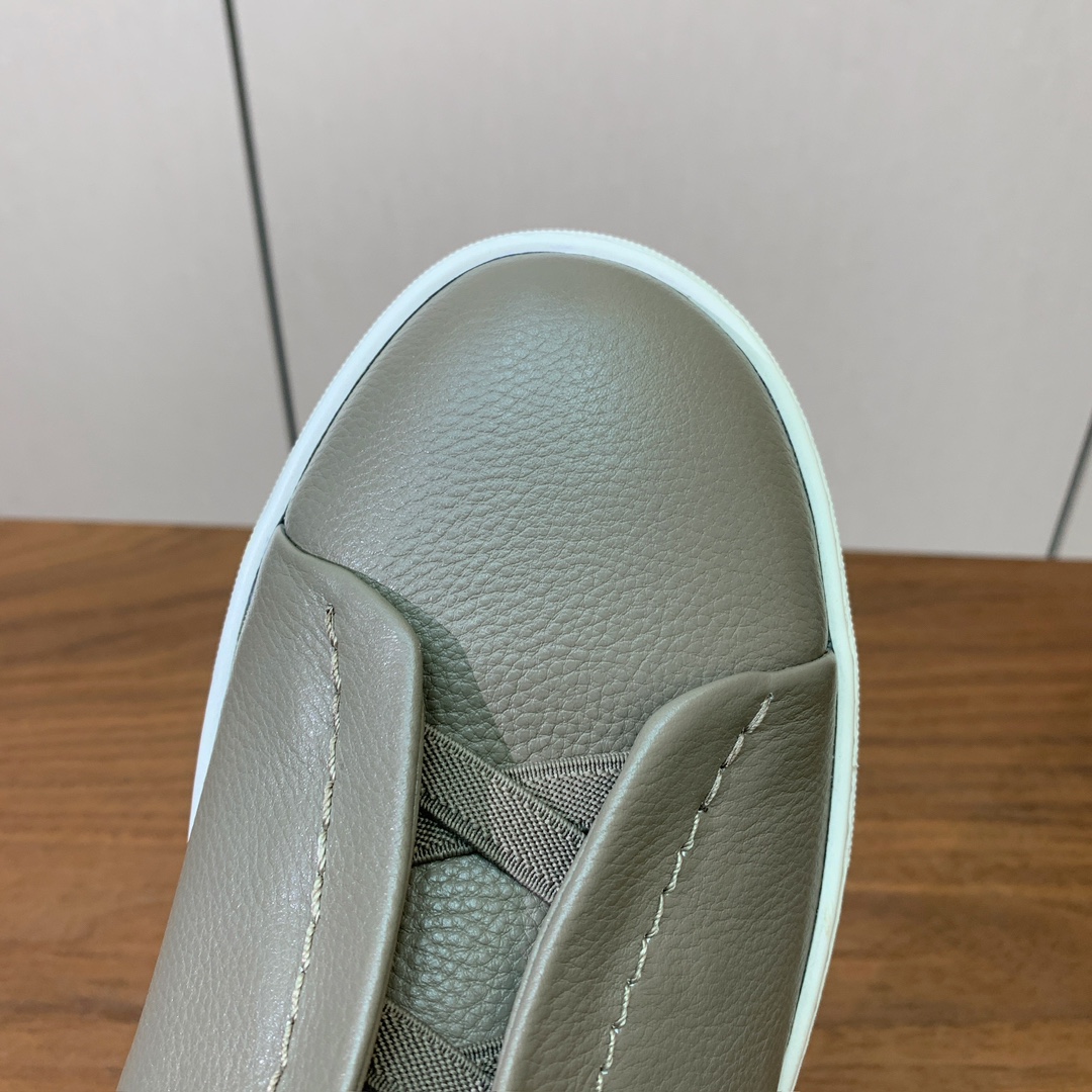 【Zegna】荔枝纹一脚蹬休闲鞋。饰有标志性三重交叉松紧细节，灵感源于三重手缝线迹造型，彰显了杰尼亚的悠