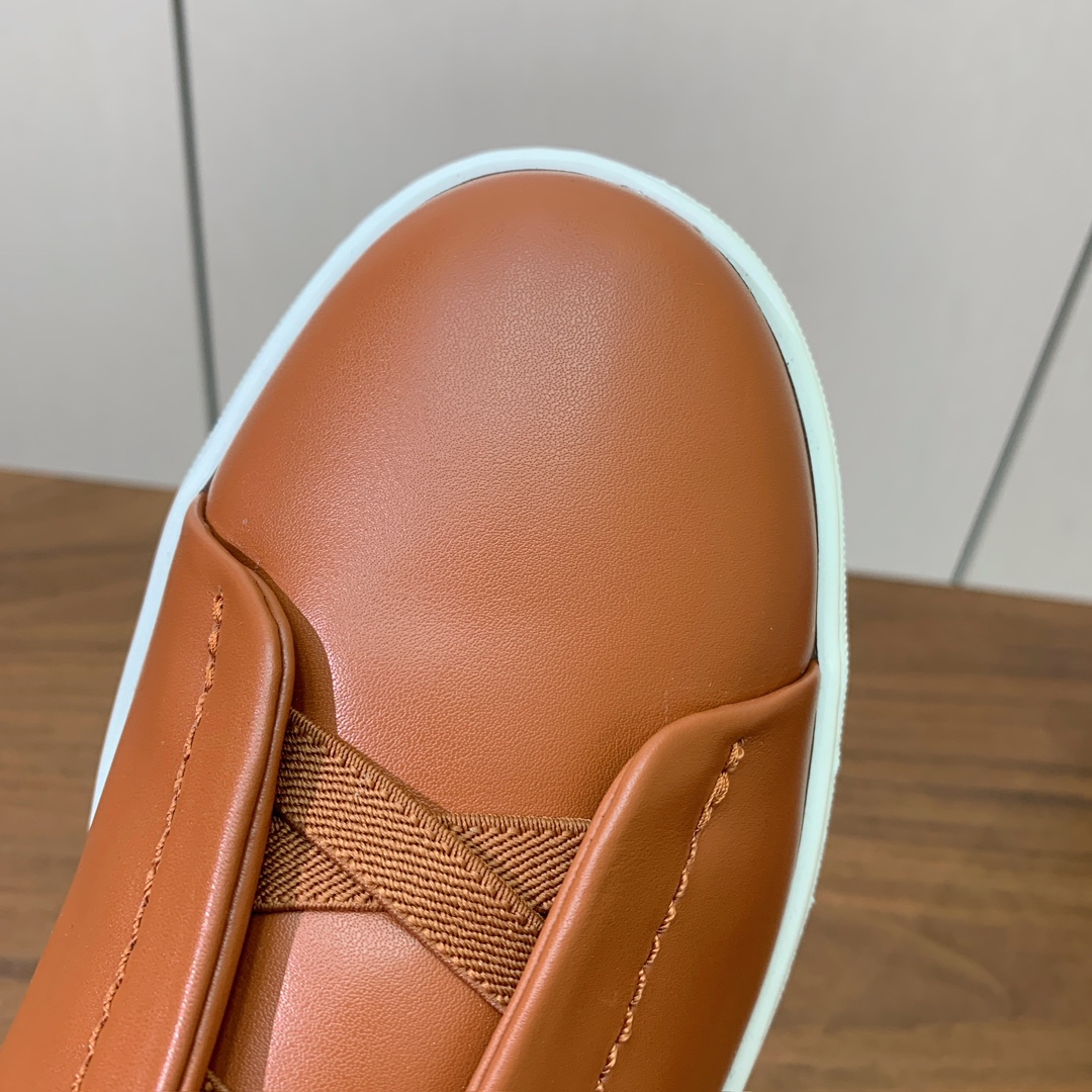 【Zegna】光面牛皮一脚蹬休闲鞋。饰有标志性三重交叉松紧细节，灵感源于三重手缝线迹造型，彰显了杰尼亚的