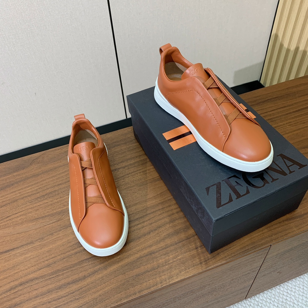 【Zegna】光面牛皮一脚蹬休闲鞋。饰有标志性三重交叉松紧细节，灵感源于三重手缝线迹造型，彰显了杰尼亚的