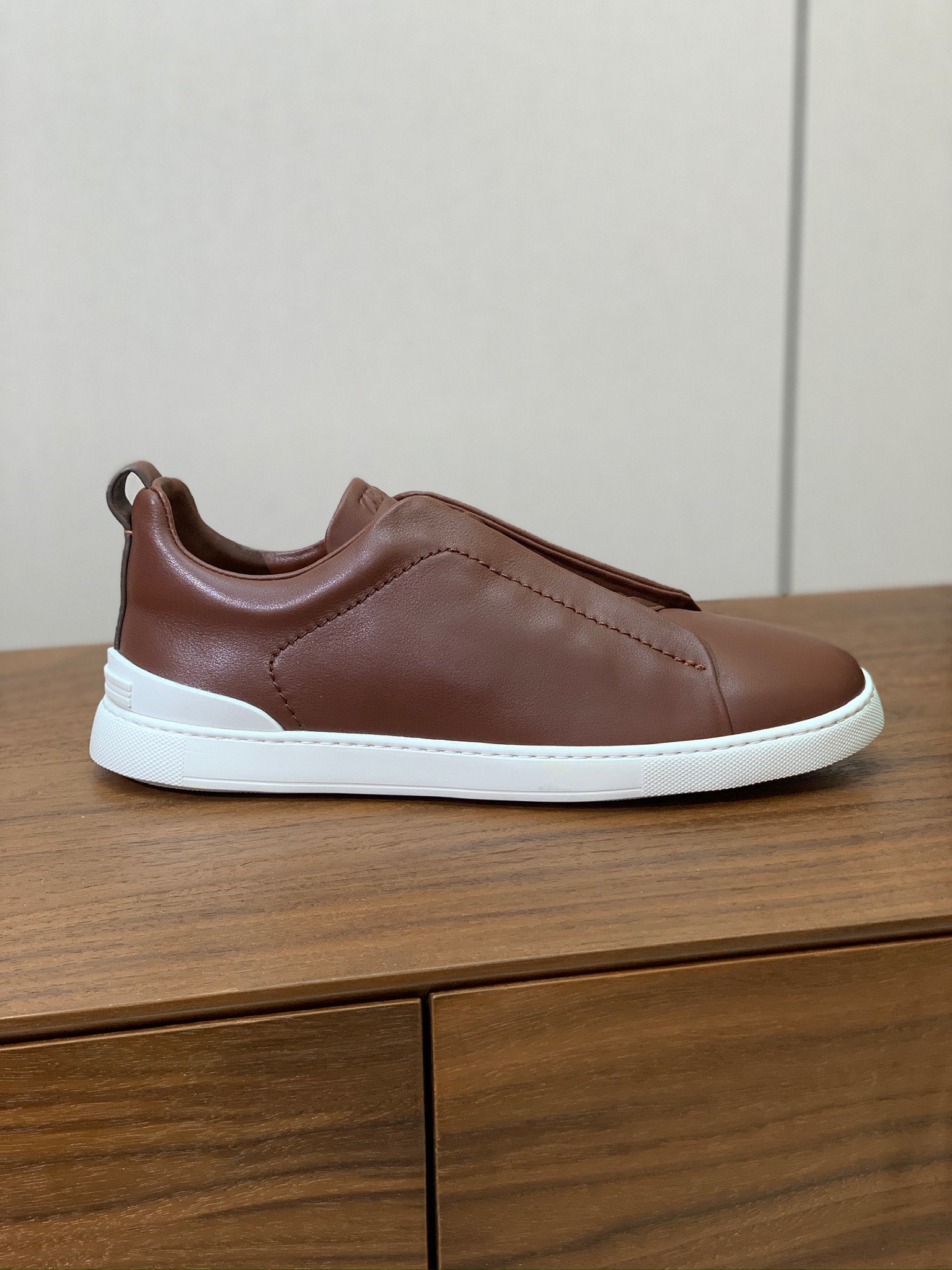 【Zegna】光面牛皮一脚蹬休闲鞋。饰有标志性三重交叉松紧细节，灵感源于三重手缝线迹造型，彰显了杰尼亚的