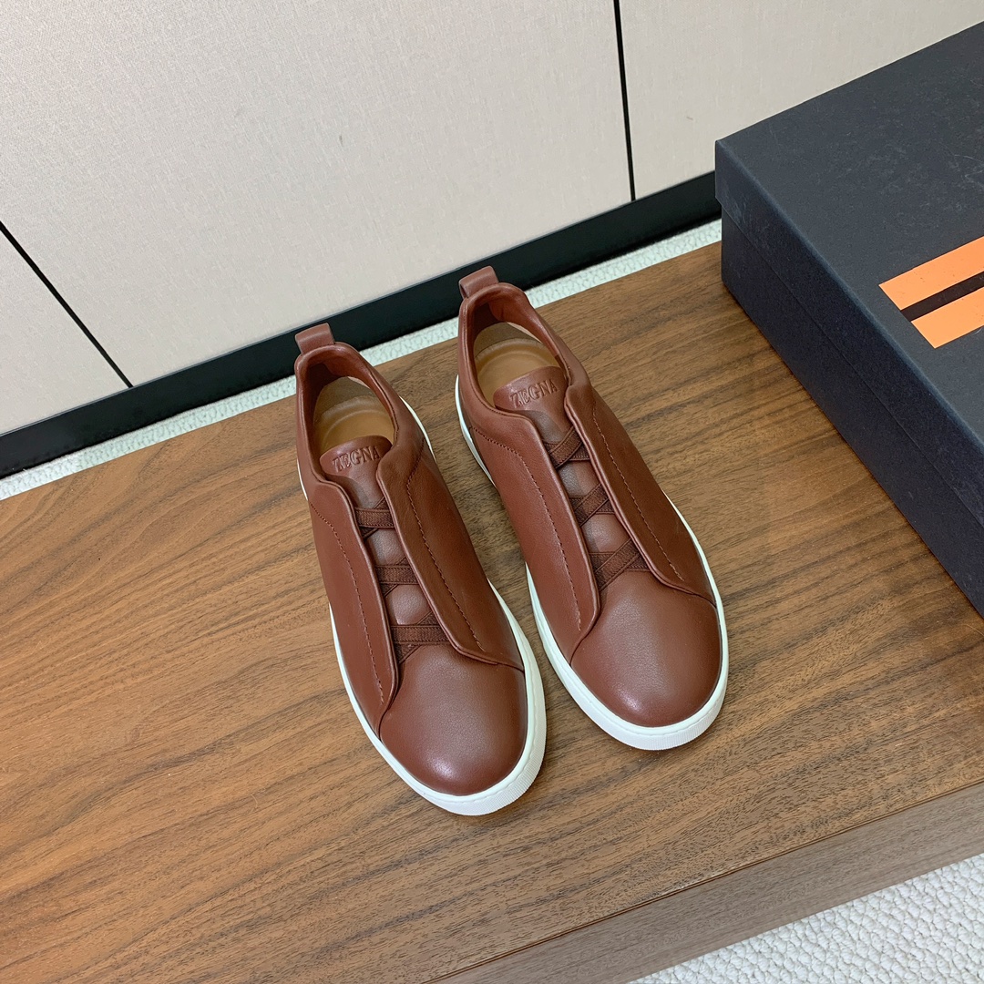 【Zegna】光面牛皮一脚蹬休闲鞋。饰有标志性三重交叉松紧细节，灵感源于三重手缝线迹造型，彰显了杰尼亚的