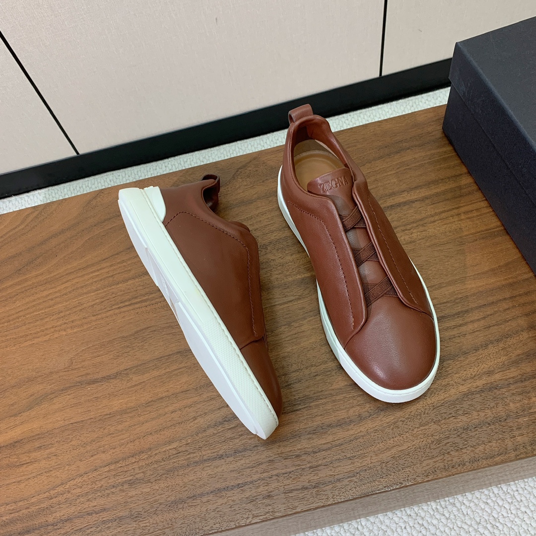 【Zegna】光面牛皮一脚蹬休闲鞋。饰有标志性三重交叉松紧细节，灵感源于三重手缝线迹造型，彰显了杰尼亚的