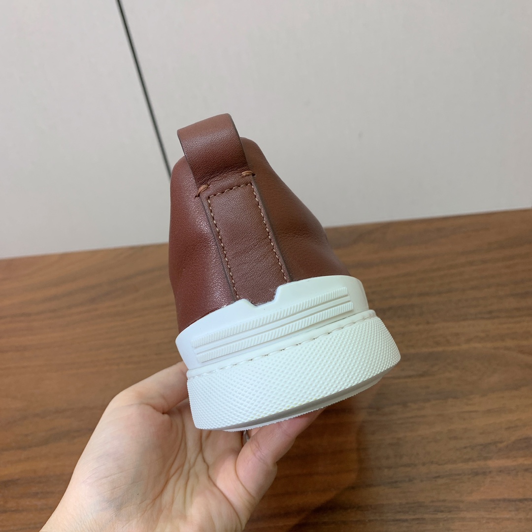 【Zegna】光面牛皮一脚蹬休闲鞋。饰有标志性三重交叉松紧细节，灵感源于三重手缝线迹造型，彰显了杰尼亚的