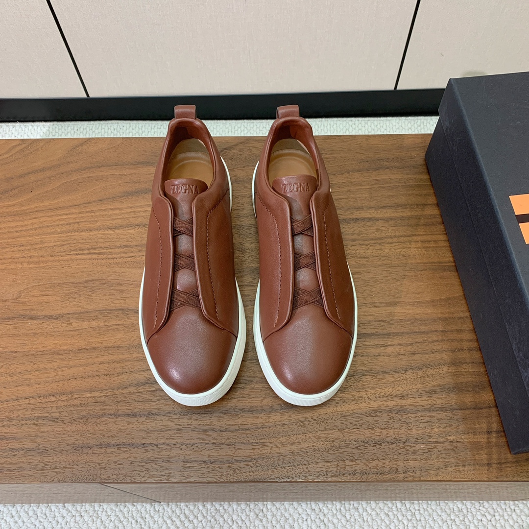 【Zegna】光面牛皮一脚蹬休闲鞋。饰有标志性三重交叉松紧细节，灵感源于三重手缝线迹造型，彰显了杰尼亚的