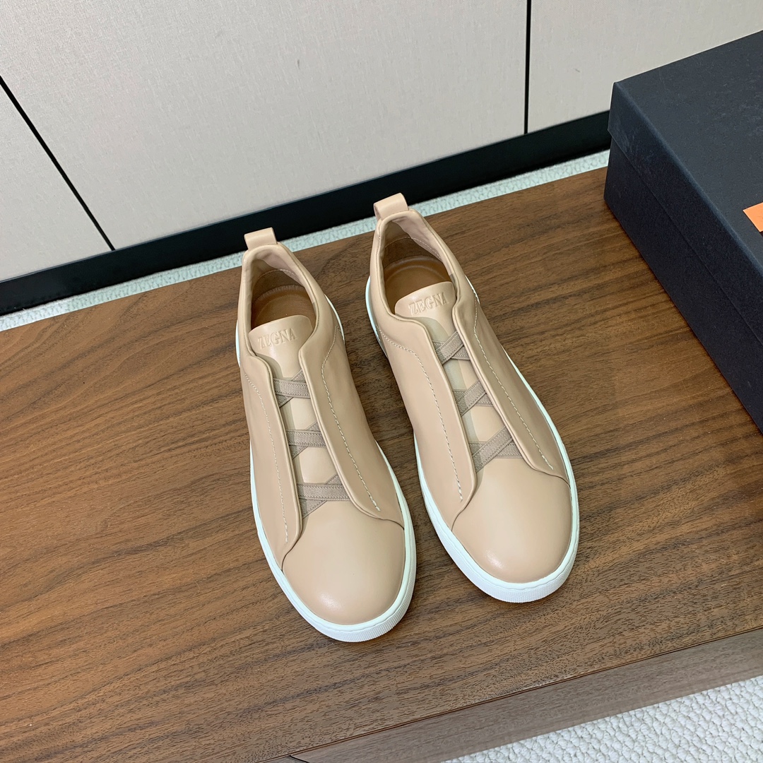 【Zegna】光面牛皮一脚蹬休闲鞋。饰有标志性三重交叉松紧细节，灵感源于三重手缝线迹造型，彰显了杰尼亚的