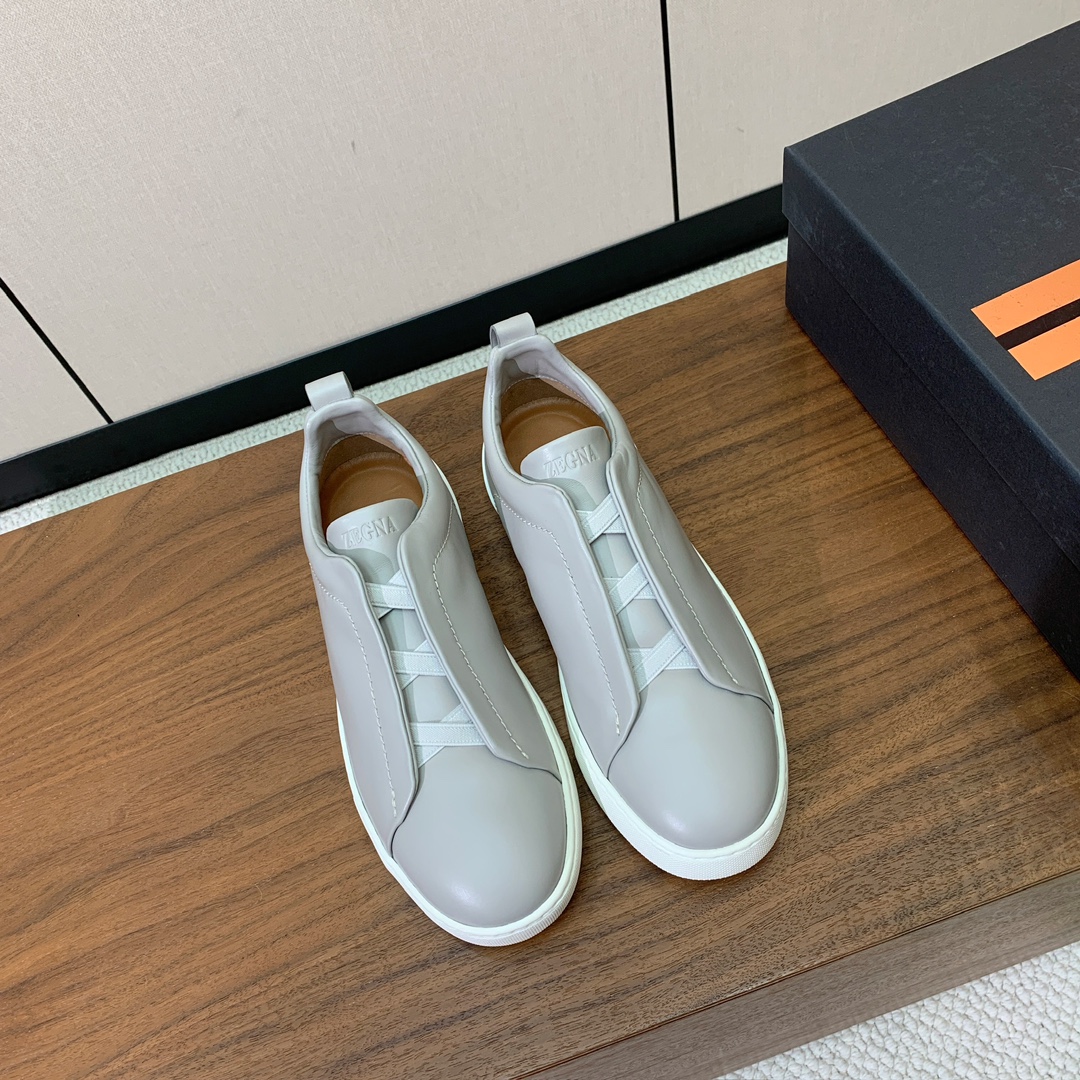 【Zegna】光面牛皮一脚蹬休闲鞋。饰有标志性三重交叉松紧细节，灵感源于三重手缝线迹造型，彰显了杰尼亚的
