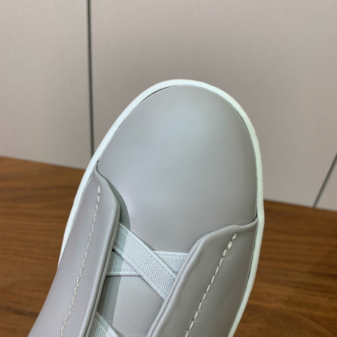 【Zegna】光面牛皮一脚蹬休闲鞋。饰有标志性三重交叉松紧细节，灵感源于三重手缝线迹造型，彰显了杰尼亚的