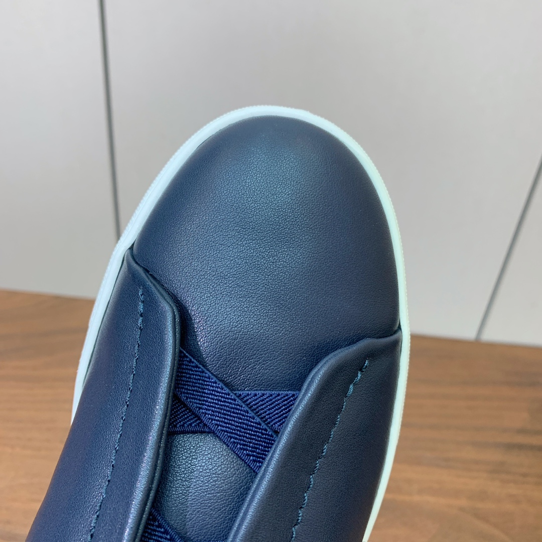 【Zegna】光面牛皮一脚蹬休闲鞋。饰有标志性三重交叉松紧细节，灵感源于三重手缝线迹造型，彰显了杰尼亚的