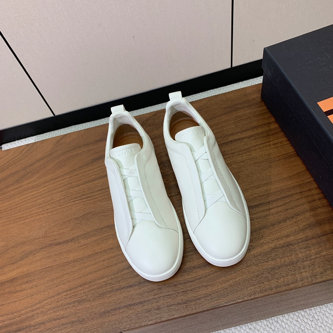 【Zegna】光面牛皮一脚蹬休闲鞋。饰有标志性三重交叉松紧细节，灵感源于三重手缝线迹造型，彰显了杰尼亚的