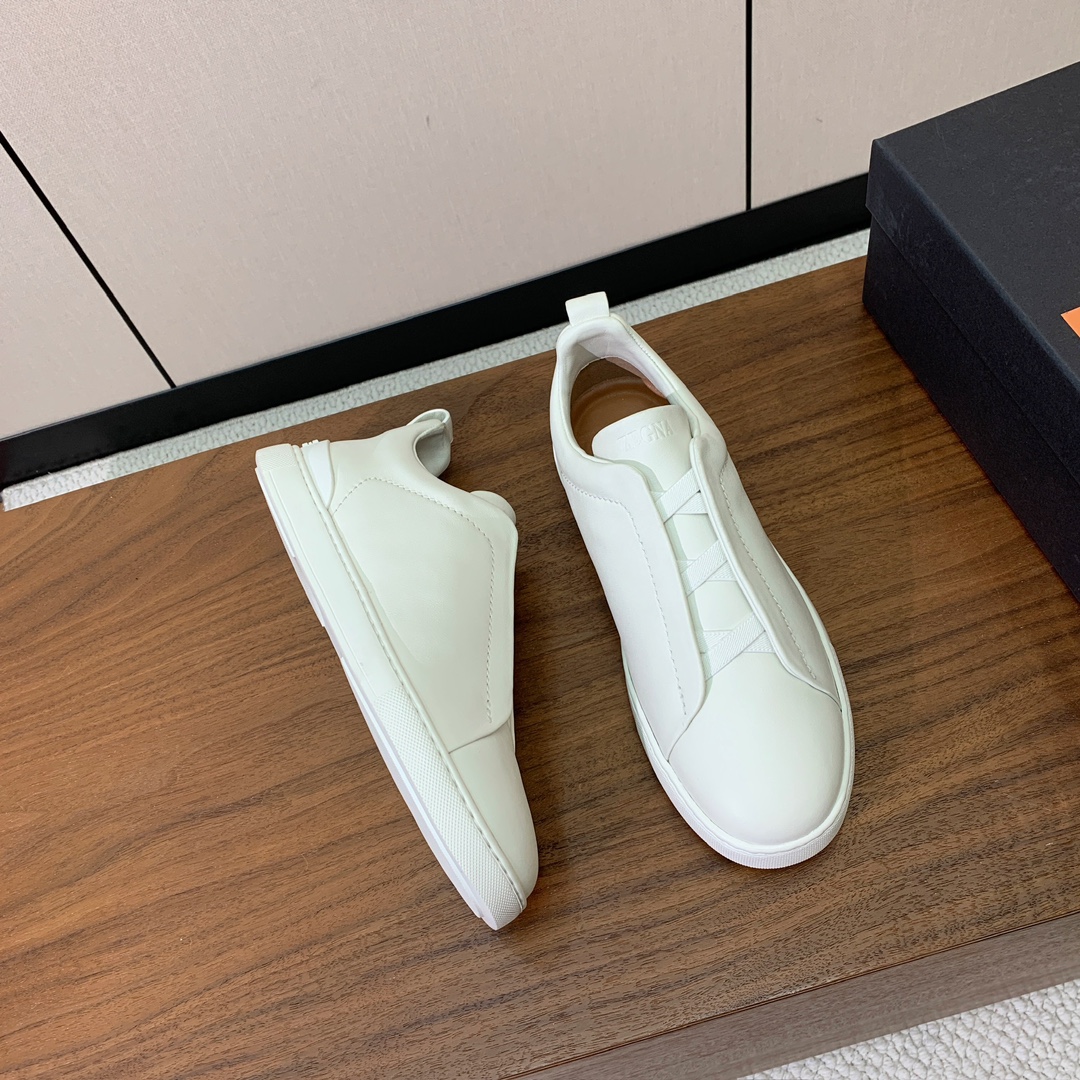 【Zegna】光面牛皮一脚蹬休闲鞋。饰有标志性三重交叉松紧细节，灵感源于三重手缝线迹造型，彰显了杰尼亚的