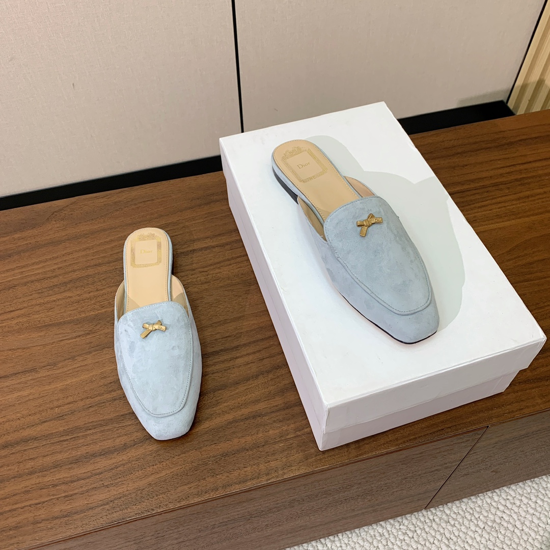 【D*or】蝴蝶结包头拖。修长方形鞋头和精致的金色饰面金属蝴蝶结装饰。采用绒面羊皮革精心制作，彰显舒适穿
