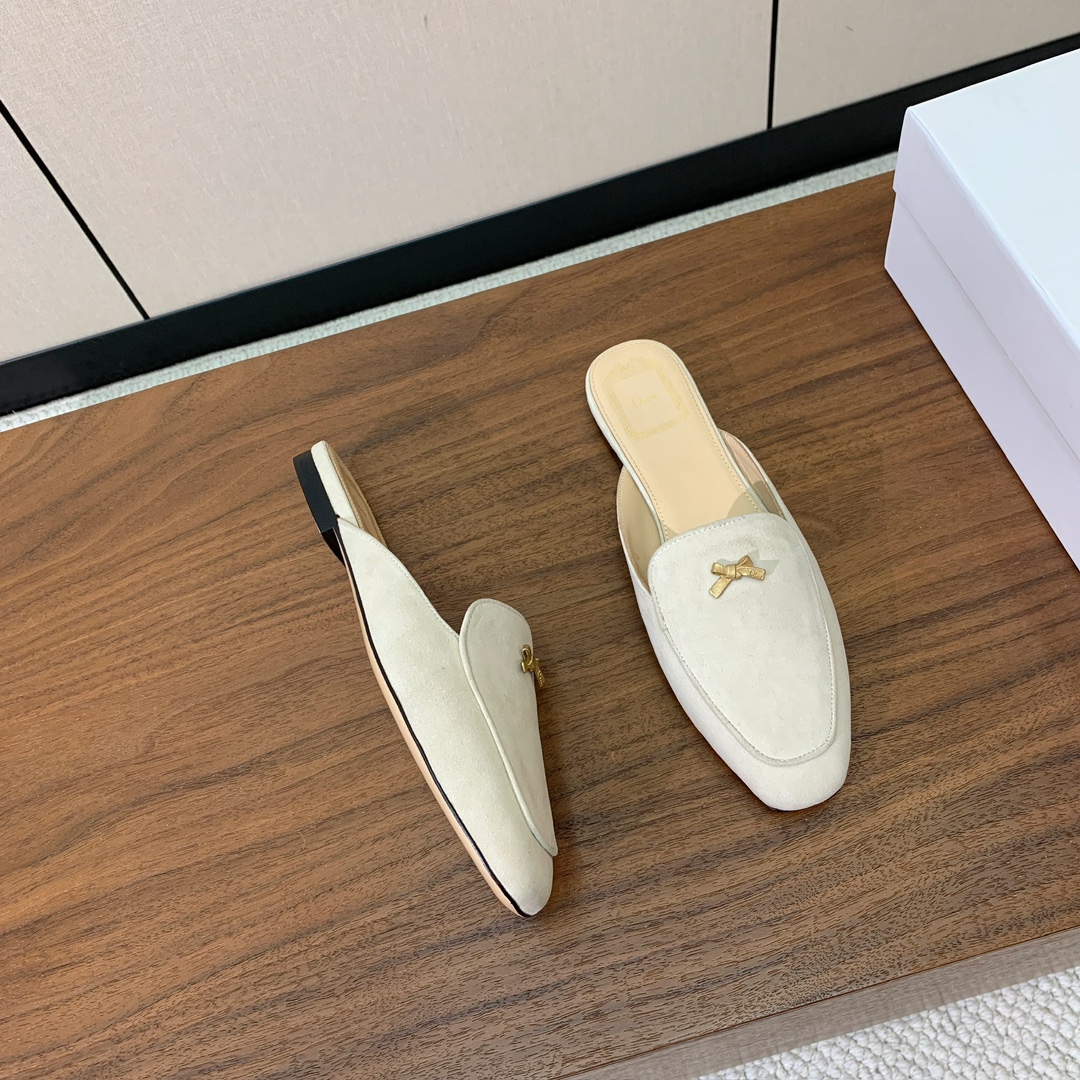 【D*or】蝴蝶结包头拖。修长方形鞋头和精致的金色饰面金属蝴蝶结装饰。采用绒面羊皮革精心制作，彰显舒适穿