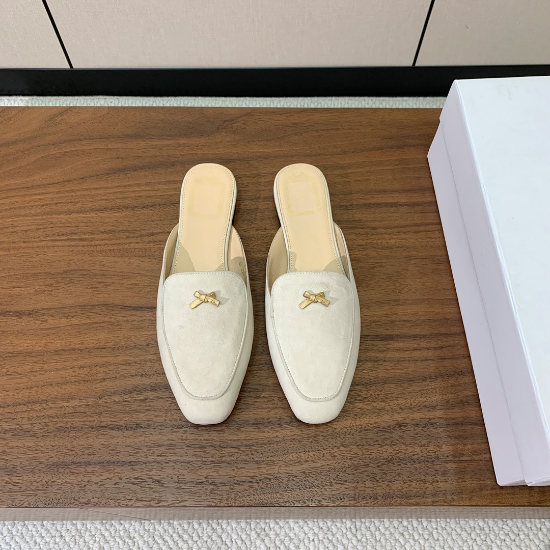 【D*or】蝴蝶结包头拖。修长方形鞋头和精致的金色饰面金属蝴蝶结装饰。采用绒面羊皮革精心制作，彰显舒适穿