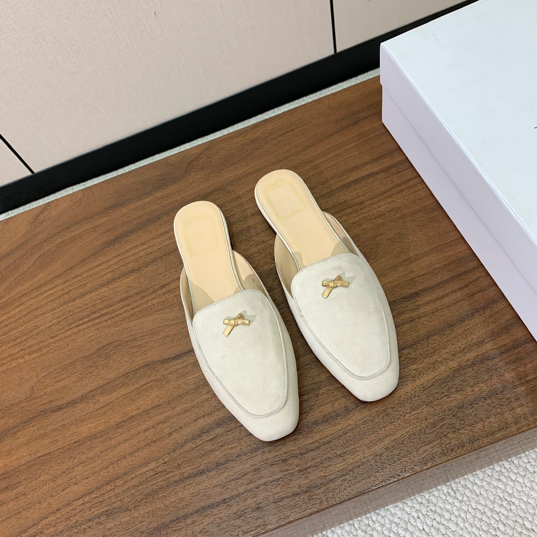 【D*or】蝴蝶结包头拖。修长方形鞋头和精致的金色饰面金属蝴蝶结装饰。采用绒面羊皮革精心制作，彰显舒适穿
