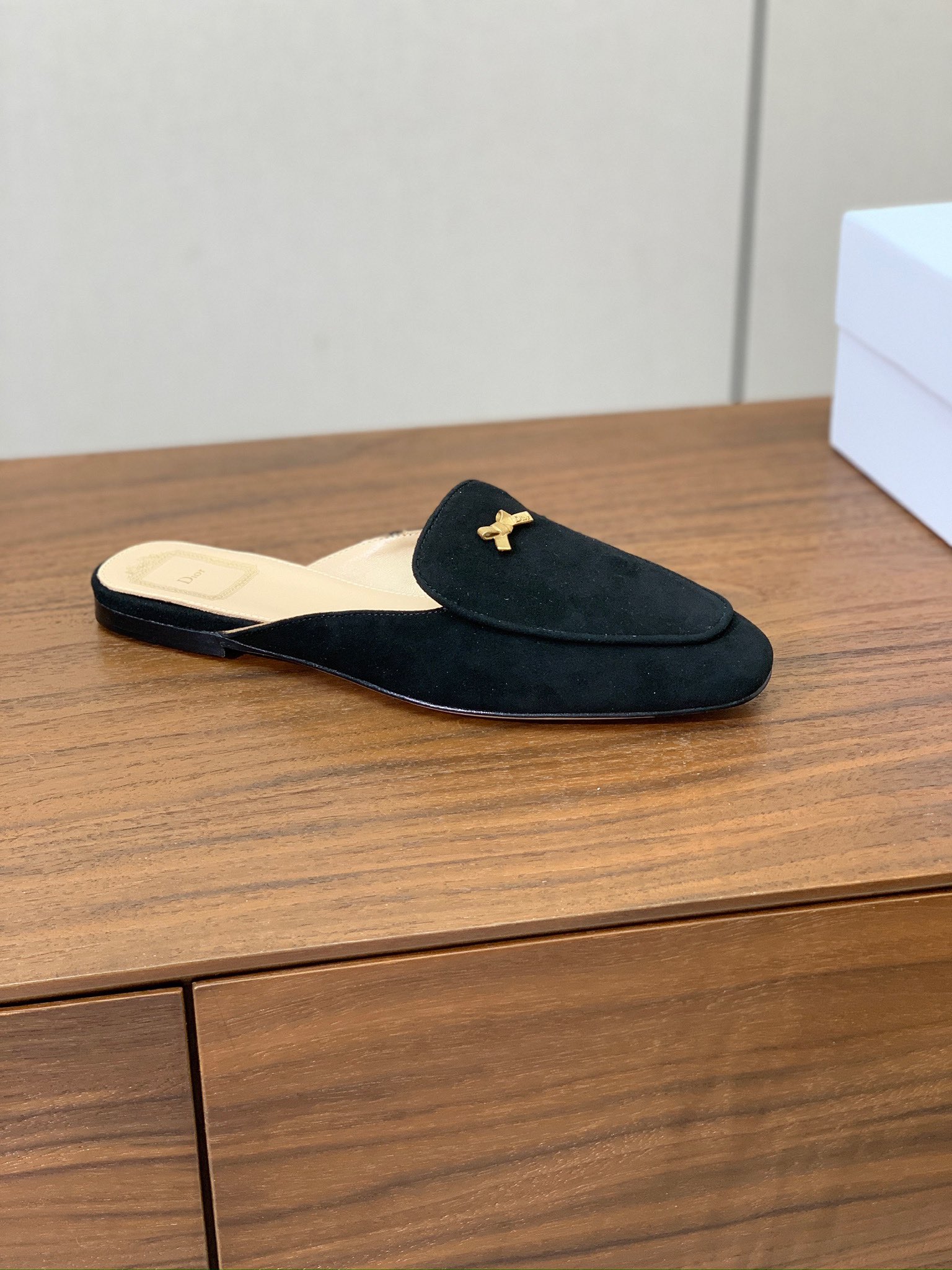 【D*or】蝴蝶结包头拖。修长方形鞋头和精致的金色饰面金属蝴蝶结装饰。采用绒面羊皮革精心制作，彰显舒适穿