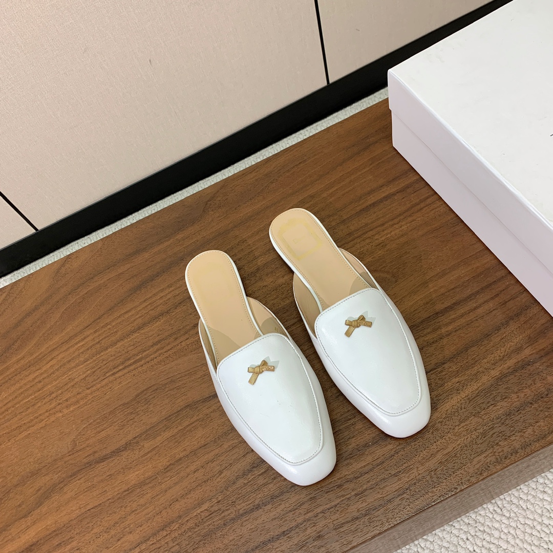 【D*or】蝴蝶结包头拖。修长方形鞋头和精致的金色饰面金属蝴蝶结装饰。采用绒面羊皮革精心制作，彰显舒适穿