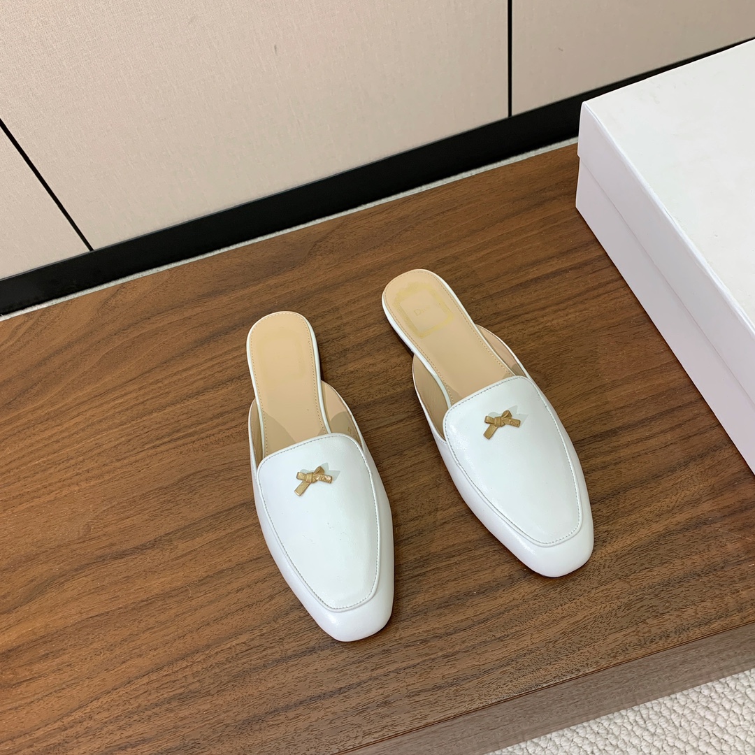 【D*or】蝴蝶结包头拖。修长方形鞋头和精致的金色饰面金属蝴蝶结装饰。采用绒面羊皮革精心制作，彰显舒适穿