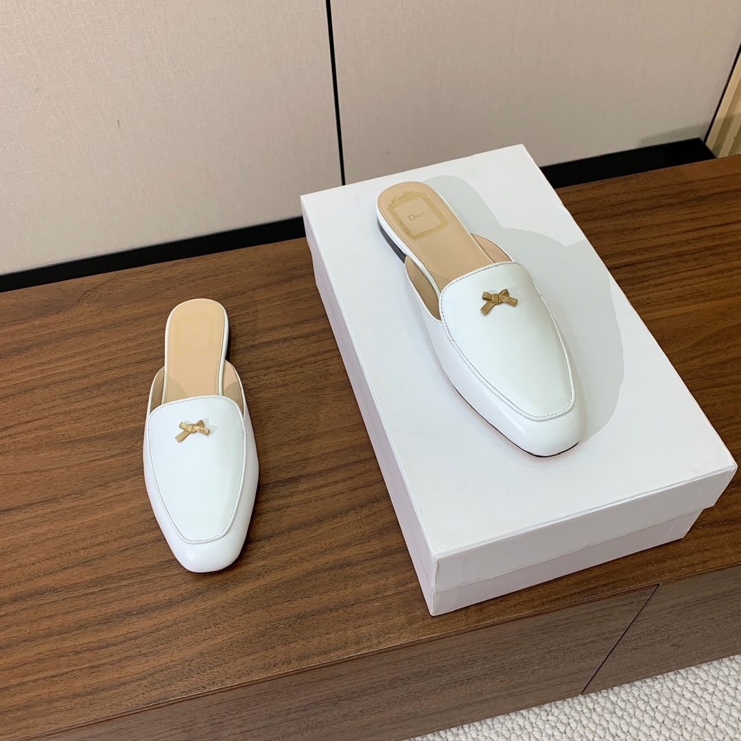 【D*or】蝴蝶结包头拖。修长方形鞋头和精致的金色饰面金属蝴蝶结装饰。采用绒面羊皮革精心制作，彰显舒适穿