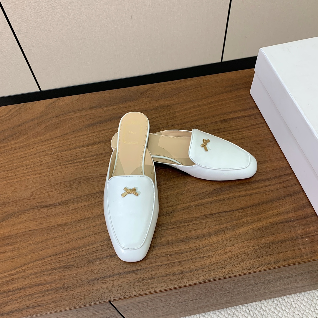 【D*or】蝴蝶结包头拖。修长方形鞋头和精致的金色饰面金属蝴蝶结装饰。采用绒面羊皮革精心制作，彰显舒适穿