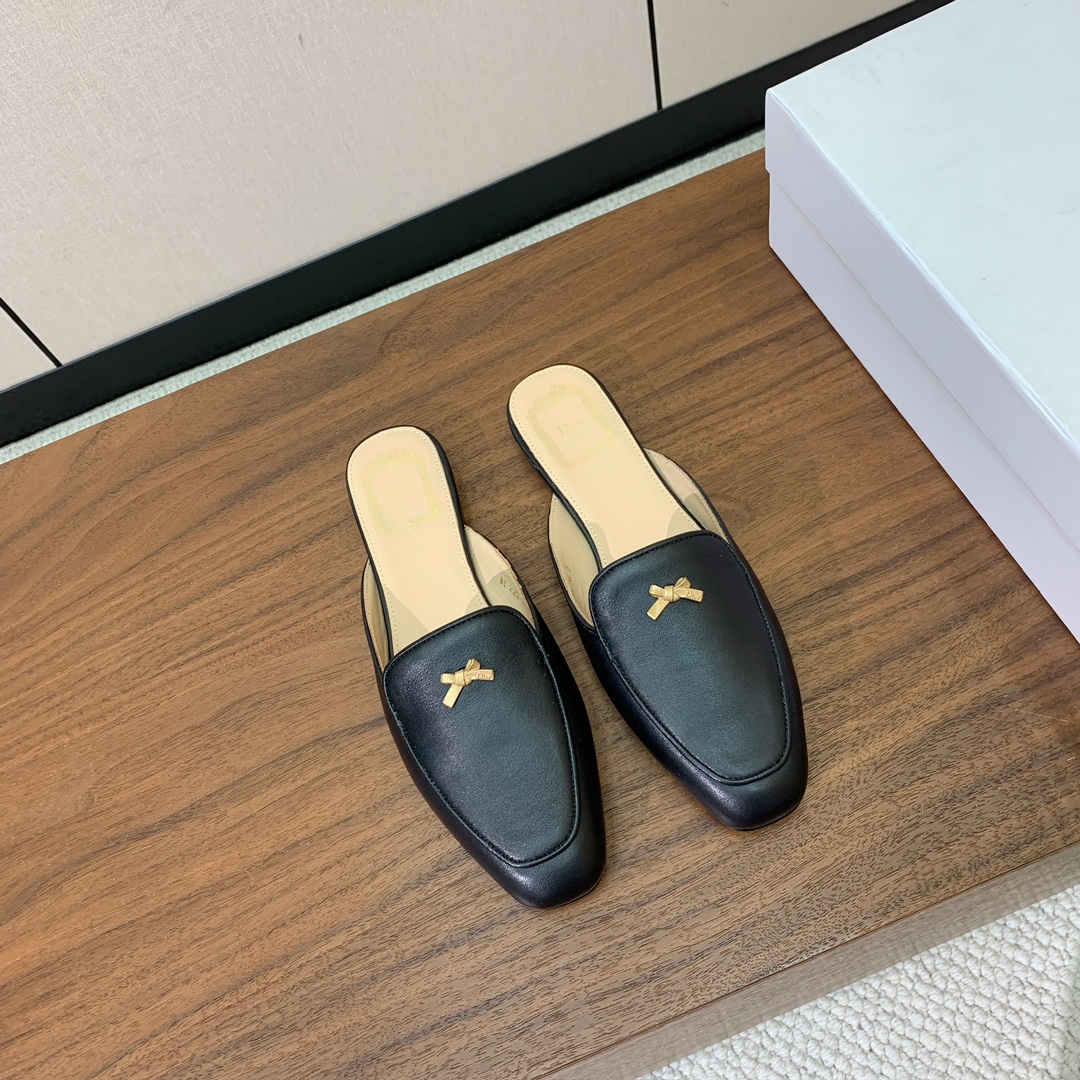 【D*or】蝴蝶结包头拖。修长方形鞋头和精致的金色饰面金属蝴蝶结装饰。采用绒面羊皮革精心制作，彰显舒适穿