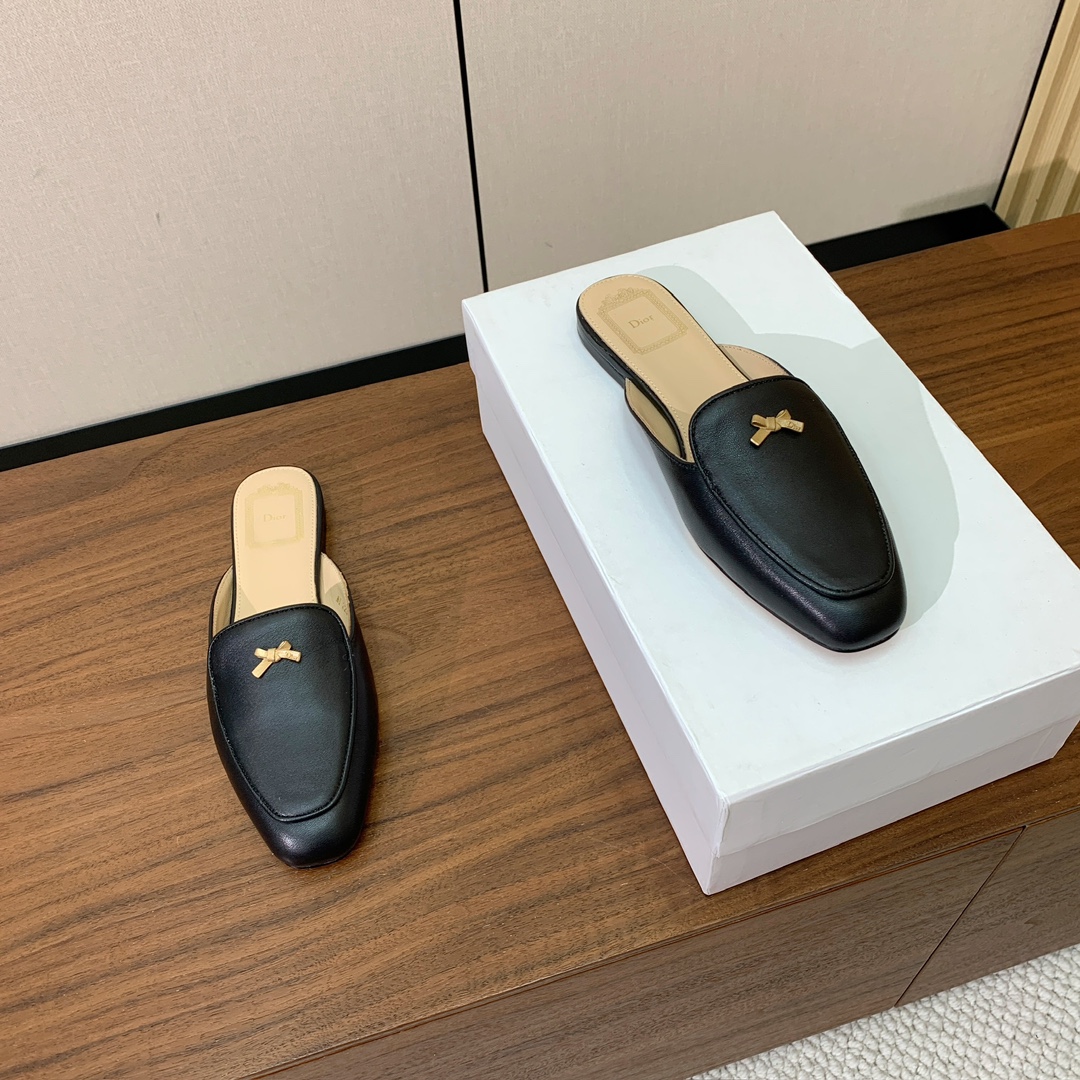 【D*or】蝴蝶结包头拖。修长方形鞋头和精致的金色饰面金属蝴蝶结装饰。采用绒面羊皮革精心制作，彰显舒适穿