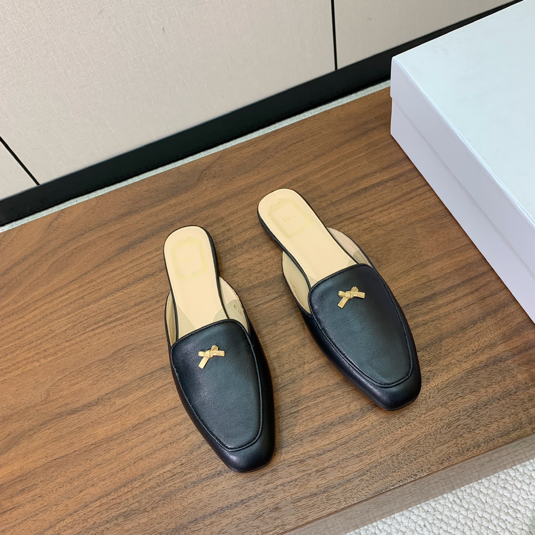 【D*or】蝴蝶结包头拖。修长方形鞋头和精致的金色饰面金属蝴蝶结装饰。采用绒面羊皮革精心制作，彰显舒适穿
