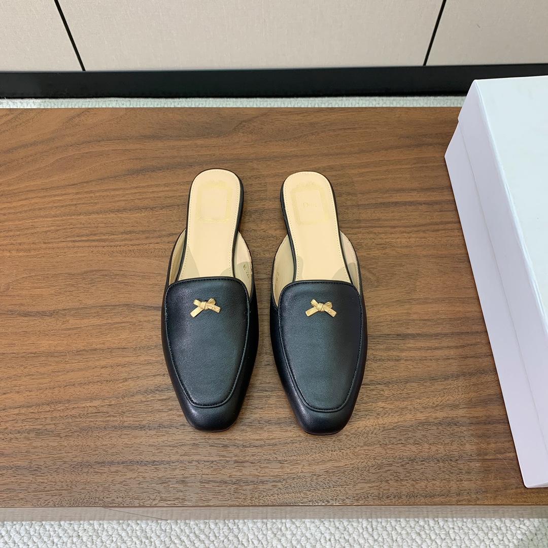 【D*or】蝴蝶结包头拖。修长方形鞋头和精致的金色饰面金属蝴蝶结装饰。采用绒面羊皮革精心制作，彰显舒适穿