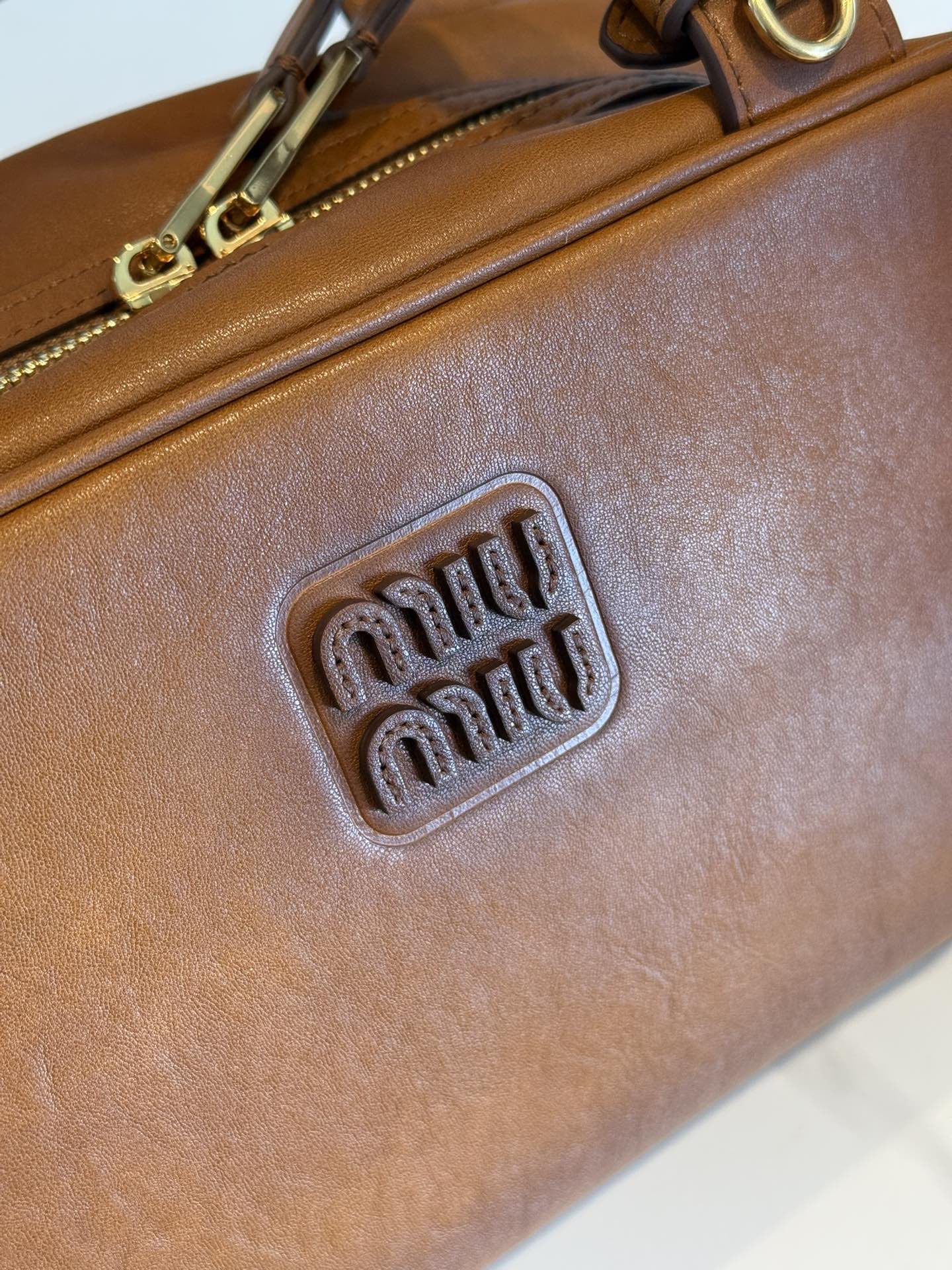 P780 Mi* 25秋冬新款 紧凑而多功能 采用全新小牛皮材质 质感柔软高级  微妙的光泽特色重新诠释 演绎平坦的手柄 饰以压花压花字母 增添标志性元素 体现了miu的精致  内配拉链口袋  
  5BB182
  尺寸：28×15×13cm