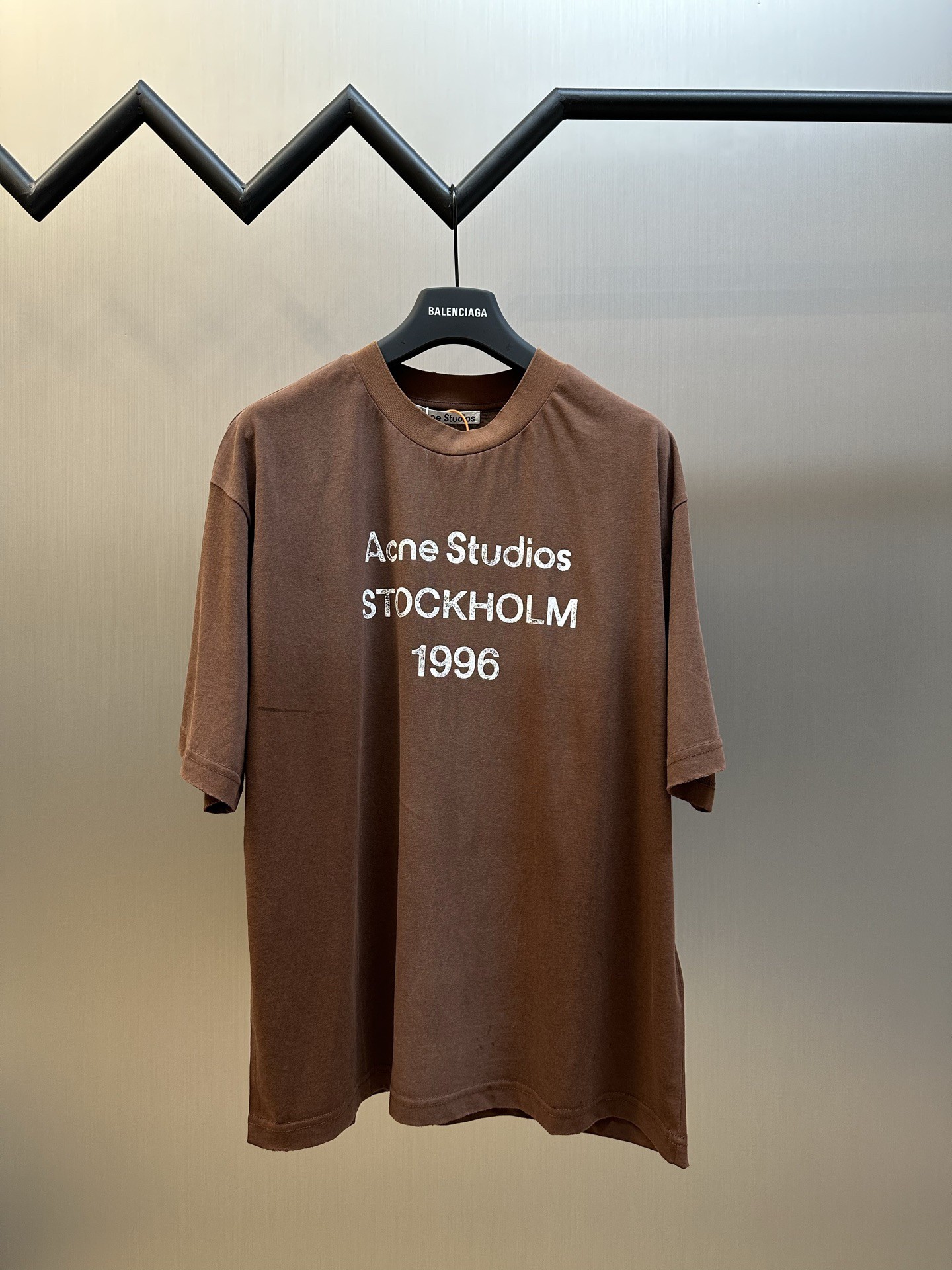 NO:845728,Acne spray-painted distressed logo short-sleeves, custom-made cloud velvet cool ski-like cotton, chocolate brown lightly opens the curtain, quiet and romantic, with a sense of oppressive luxury. The Acne Studios 1996 logo pattern is embellished on the chest. The uneven depth of the letter strokes is like a mark engraved by the years. It is sublimated by the imperfection of the distressed spray-painting, forming a visual collision of softness and strength.  Glue printing is used, and the chest printing has been modified three times with the film screen. The glue liquid paint is used to print the pattern on the fabric, and the fabric is baked to fix the printed pattern. Gradient distressing spray process, by spraying dyes of different colors on the surface of the fabric, realizes the rich color changes of the clothes under different lights, increasing the visual layering. Many parts of the body are worn by pure manual regular positioning, and manual brushing marks are added to the surface of the clothing to add texture and depth to imitate the texture of natural wear and tear. sizes m l  xl,,acne studios,dior,T-shirt,19860909Acne 喷绘做旧徽标短袖 定制云绒爽滑雪感棉,巧克力棕轻启帷幕,静谧而浪漫,自带的压迫性高级感,Acne Studios 1996徽标图案点缀于胸前,字母笔触的深浅不均,宛如岁月镌刻的印记,加以喷绘做旧的不完美感为升华,形成柔与刚的视觉碰撞 采用胶浆印花,胸前印花经过三次菲林网板修改,使用胶浆液体涂料在织物上打印图案,烘烤织物以固定印刷图案. 渐变做旧喷马骝工艺,通过在织物表面喷洒不同颜色的染料,实现衣物在不同光线下呈现出丰富的色彩变化,增加视觉层次感 衣身多处皆由纯人工规律性定位磨破,手工刷痕 在衣物表面增加纹理和深度感,以模仿自然磨损的质感 sizes m l xl,,acne studios,dior,T-shirt,,Men's clothing