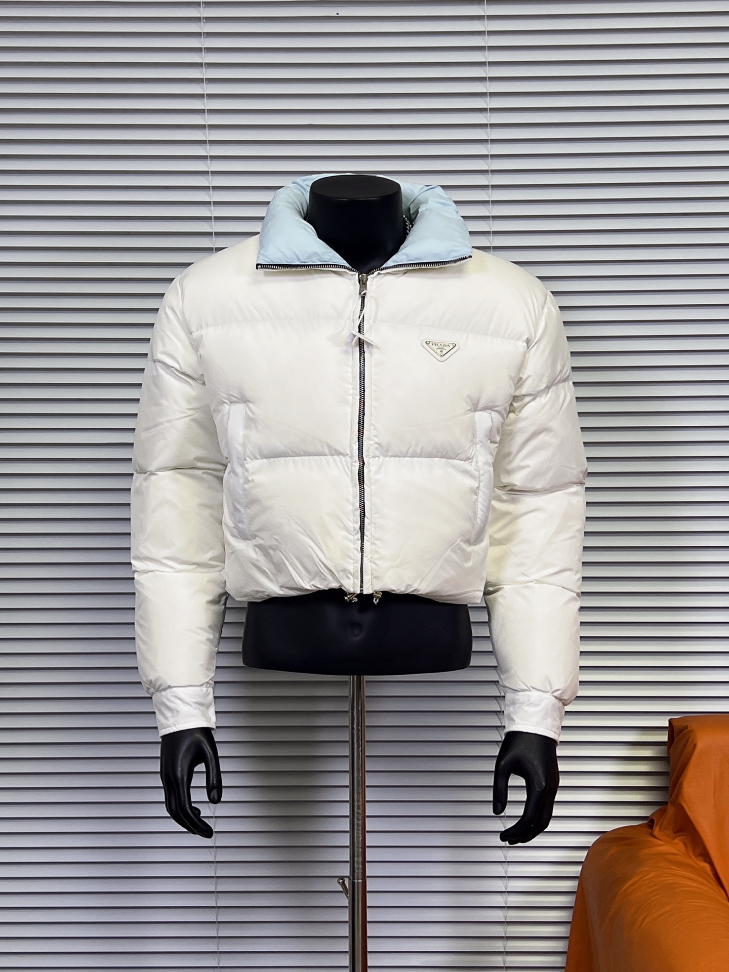 工厂直供💰280
普拉达PRADA 女士短款羽绒服🤫

描述：Prada-短款羽绒服这款羽绒外套采用Re-Nvlon再生尼龙打造，融合现代设计和新颖计的短裁版型。 

材料工艺解析： 
1、"白鸭绒绒加衬给予温暖防护，标志性的涂珐琅金属三角形徽标彰显品牌格调。 
2、创新性Re-Nvlon再生尼龙通过提纯海洋塑料回收物制成，是品牌标志性的面料。 
3、短裁版型鹅绒加衬·立领衬衫袖拉链拉合拉链式嵌线袋织物束绳下摆涂珐琅金属三角形徽标 
4、80%纯白鸭绒，市面独家使用顶级羽绒，绝不吹虚鹅绒等一系列的错误理解 
5、面料: 100% 锦纶; 里料: 100% 锦纶 ，市面最顶级没有之一，一切遵照原版定制。 
6、原代加工厂出品电镀五金，全部原厂定制，非市场各类复刻版，真正做到1:1

颜色：黑色 白色 天蓝色
尺码：36 38 40 42