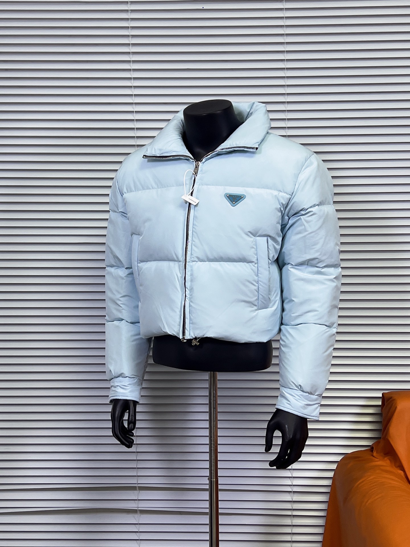 工厂直供💰280
普拉达PRADA 女士短款羽绒服🤫

描述：Prada-短款羽绒服这款羽绒外套采用Re-Nvlon再生尼龙打造，融合现代设计和新颖计的短裁版型。 

材料工艺解析： 
1、"白鸭绒绒加衬给予温暖防护，标志性的涂珐琅金属三角形徽标彰显品牌格调。 
2、创新性Re-Nvlon再生尼龙通过提纯海洋塑料回收物制成，是品牌标志性的面料。 
3、短裁版型鹅绒加衬·立领衬衫袖拉链拉合拉链式嵌线袋织物束绳下摆涂珐琅金属三角形徽标 
4、80%纯白鸭绒，市面独家使用顶级羽绒，绝不吹虚鹅绒等一系列的错误理解 
5、面料: 100% 锦纶; 里料: 100% 锦纶 ，市面最顶级没有之一，一切遵照原版定制。 
6、原代加工厂出品电镀五金，全部原厂定制，非市场各类复刻版，真正做到1:1

颜色：黑色 白色 天蓝色
尺码：36 38 40 42